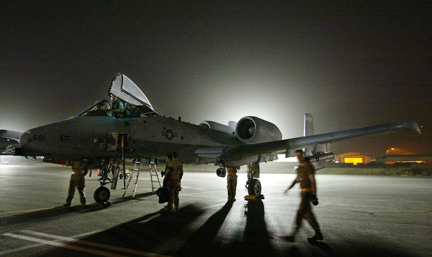 Air Force maintenance personnel go through pre-flight checks on an A-10 as work goes on through the night of March 19, 2003, at an airbase in the Persian Gulf. <em>Photo by Paula Bronstein/Getty Images</em>