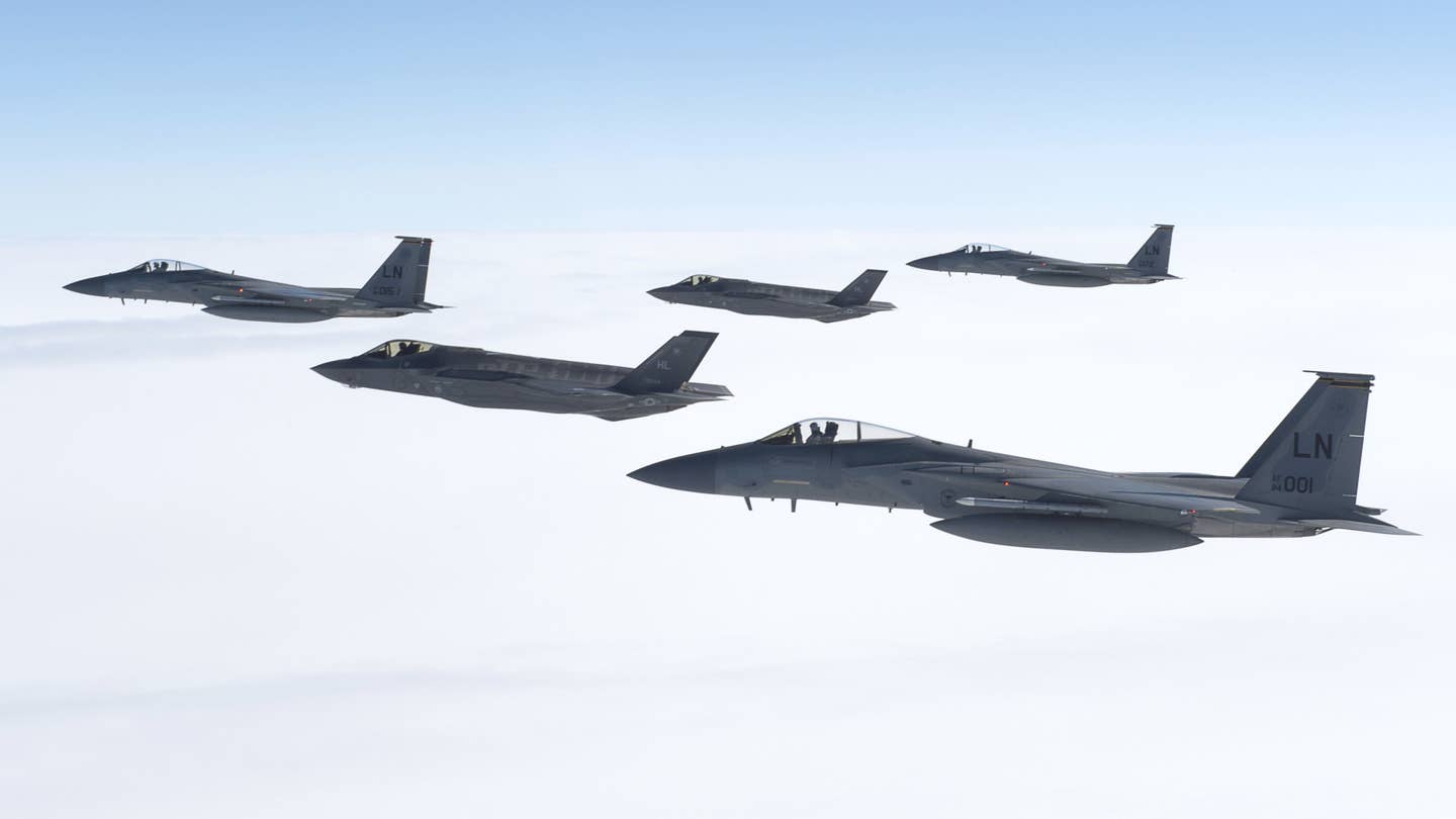 Two F-35A Joint Strike Fighters fly with a trio of F-15C Eagles. <em>USAF</em>