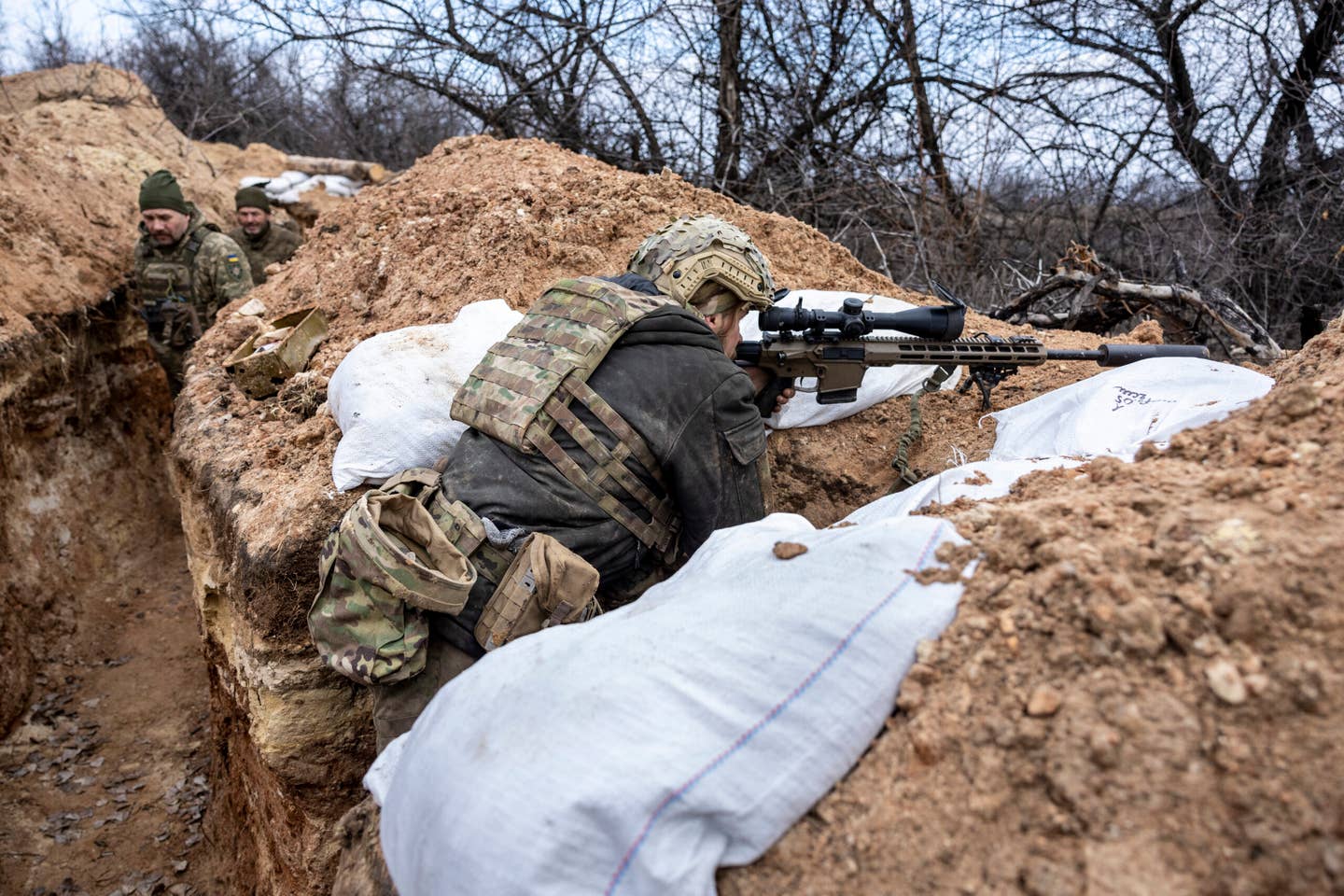 A Ukrainian sniper with the 28th Brigade looks toward a Russian position from a frontline trench on March 5, 2023, outside of Bakhmut, Ukraine. <em>Photo by John Moore/Getty Images</em>