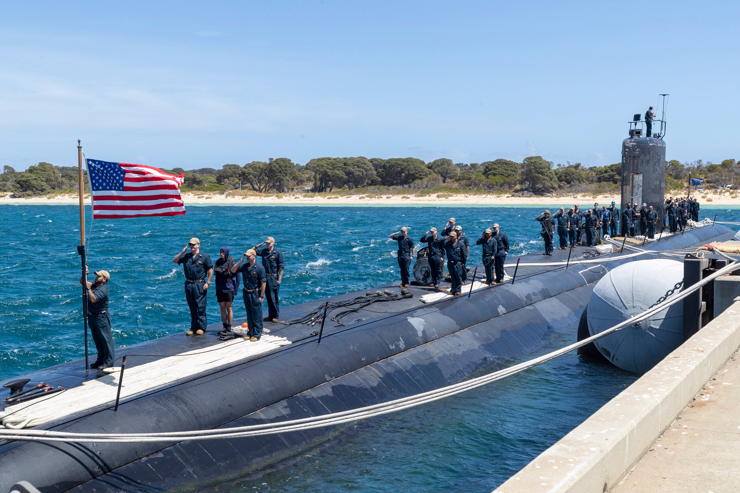 GARDEN ISLAND, Australia – Sailors assigned to the Los Angeles-class fast-attack submarine USS Asheville (SSN 758) salute the national ensign after arriving at Royal Australian Navy HMAS Stirling Naval Base, Feb. 27. Asheville is currently on patrol in support of national security interests in the U.S. 7th Fleet area of operations. (Courtesy photo by Australia Department of Defence)