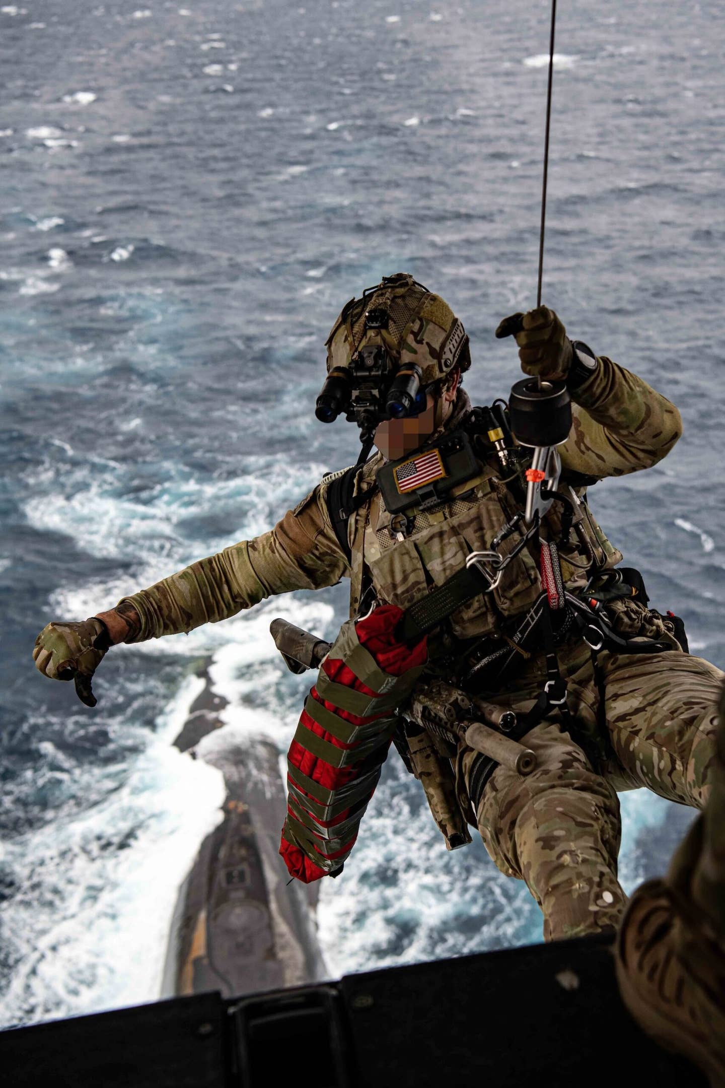 Navy SEAL begins to winch down to USS <em>Florida</em>. <em><em>U.S. Air Force photo by Tech Sgt. Westin Warburton</em></em>