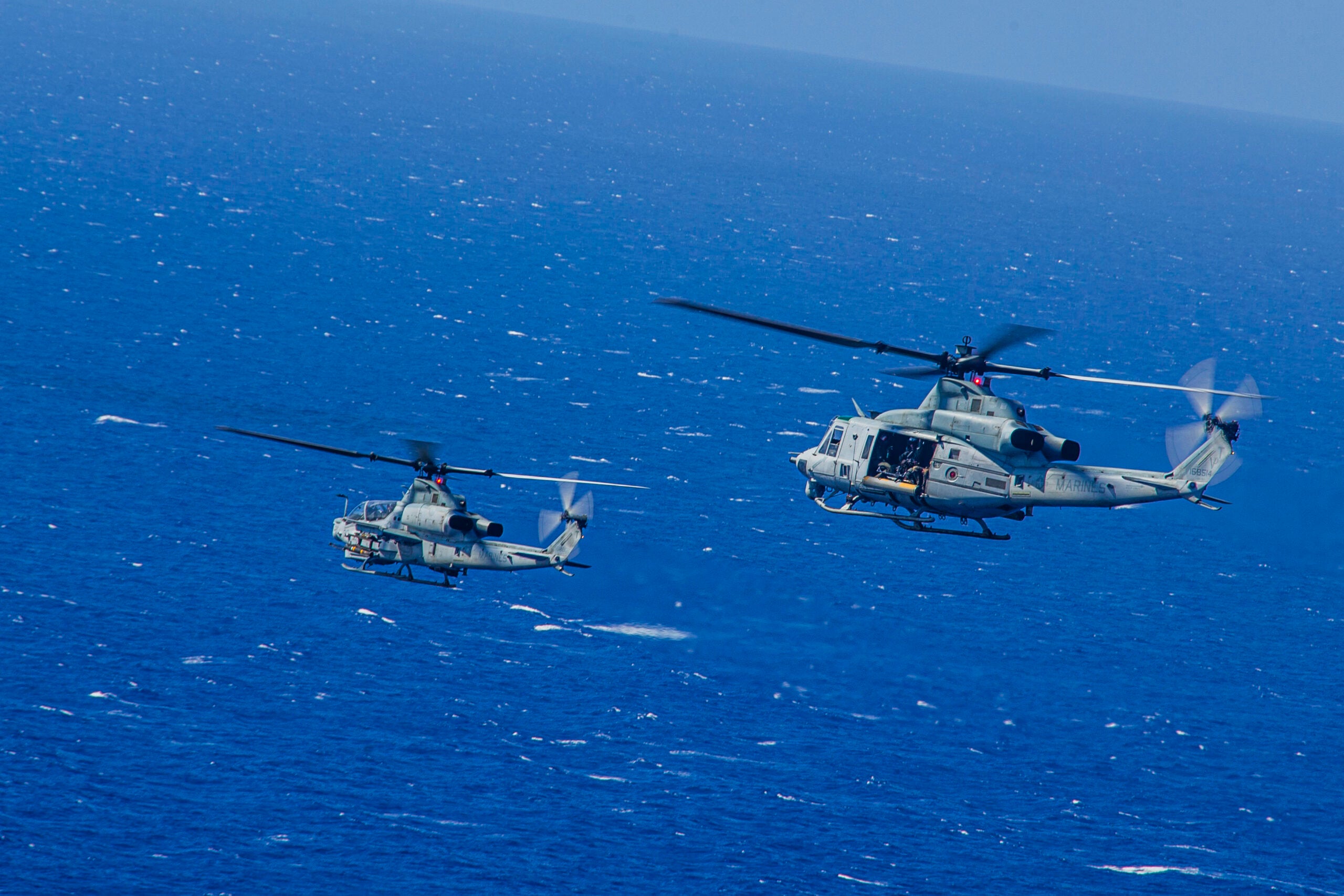 U.S. Marines with Marine Light Helicopter Attack Squadron 367 operate an AH-1Z Viper and UH-1Y Venom during a joint maritime strike exercise with U.S. Navy Helicopter Maritime Strike Squadron 37 over Pacific Missile Range Facility, Hawaii, June 9, 2020. HMLA-367 and HSM-37 conducted the training to exercise sea control and sea denial operations. (U.S. Marine Corps photo by Lance Cpl. Jacob Wilson)