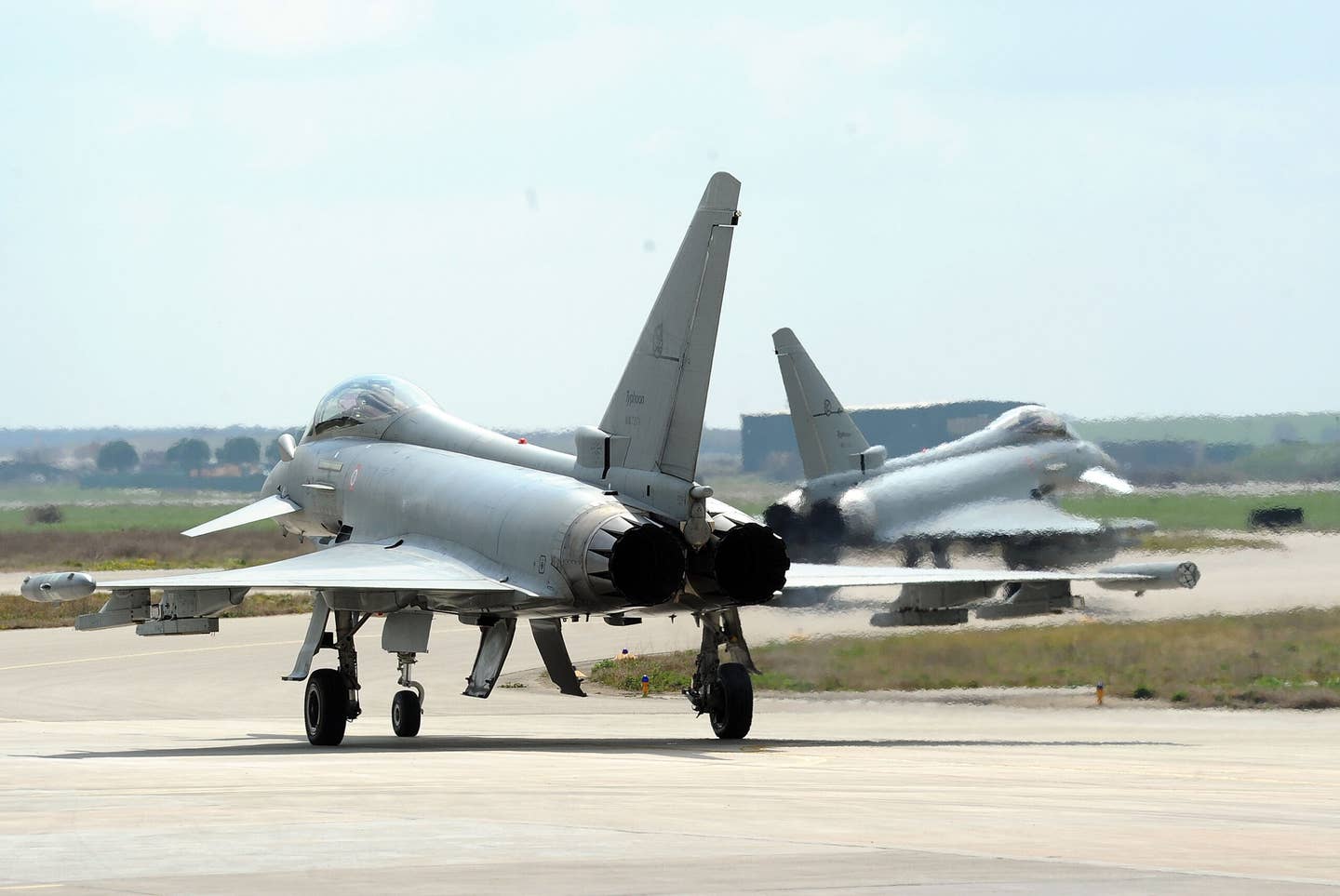 A pair of Italian Air Force F-2000 Typhoons prepare to take off from Gioia Del Colle Air Base in March 2011, for a sortie over Libya to enforce the no-fly zone there. <em>Photo by Giuseppe Bellini/Getty Images</em>
