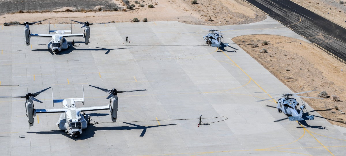 210327-N-FC670-350 Inyokern, Calif. (Mar. 27, 2021)

Two MH-60S Knighthawk helicopters assigned to the "Black Knights" of Helicopter Sea Combat Squadron (HSC) 4, stationed in San Diego, are refueled by a Navy CMV-22B Osprey from the "Titans" of Fleet Logistics Multi-Mission Squadron (VRM) 30. The CMV-22B is the U.S. Navy version of the Osprey, a multi-engine, dual-piloted, self-deployable, medium lift, vertical takeoff and landing (VTOL) tilt-rotor aircraft. The Air Delivered Ground Refueling (ADGR) evolution was a first for HSC 4, en route to Naval Air Station Fallon. Air Wing Fallon is part of the predeployment training cycle for Navy's carrier air wings.  HSC-4, along with VFA-2, VFA-192, VFA-113, VFA-147, VAQ-136, VAW-113, and HSM-78 comprise CVW-2 and are detached to NAS Fallon in order to sharpen their warfighting readiness through a rigorous 5-week curriculum.  The training conducted during Air Wing Fallon drives air wing integration and ensures that all CVW-2 squadrons are ready to conduct the full range of military operations when they deploy later this year. HSC 4 provides vertical lift search and rescue, logistics, anti-surface warfare, special operations forces support, and combat search and rescue capabilities.

(U.S. Navy photo by Chief Mass Communication Specialist Shannon Renfroe/Released)