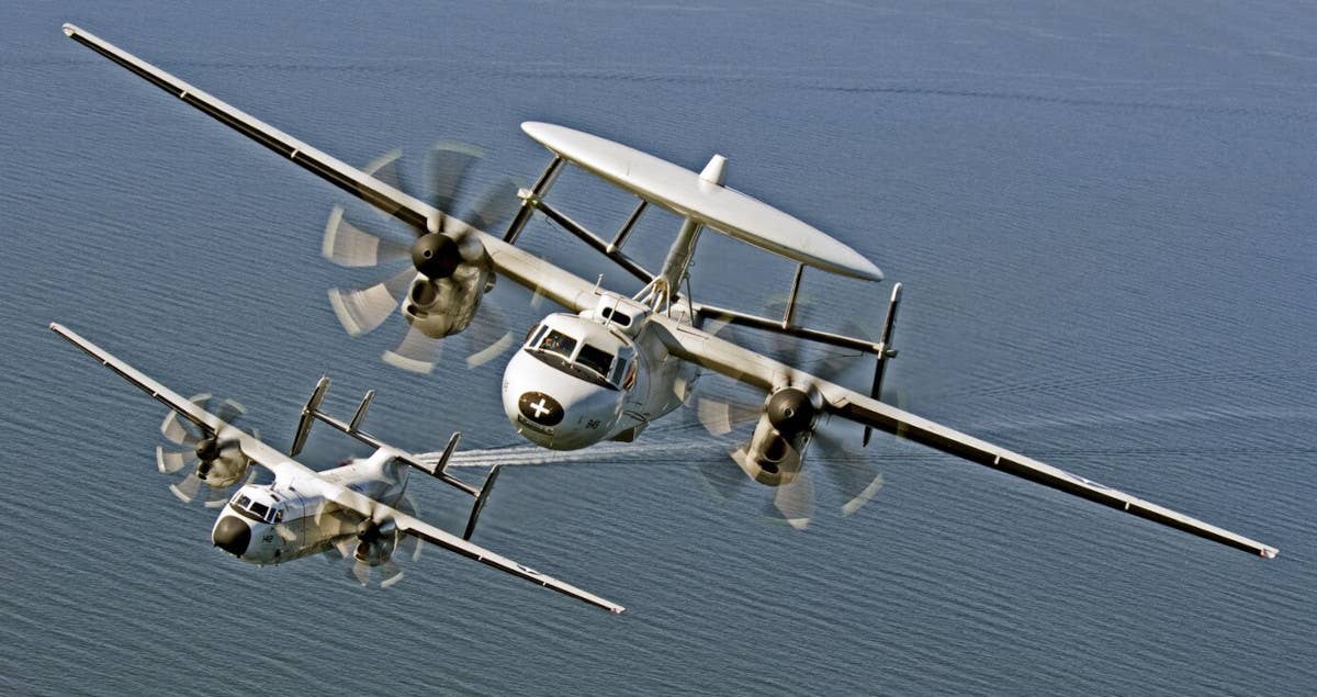 An E-2C Hawkeye, in front, flies together with a C-2A Greyound. The CMV-22B Osprey is the Navy's replacement for the C-2A, which was derived from the E-2 design. <em>USN</em>