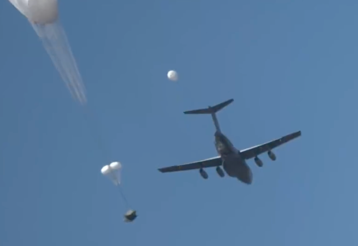 A Y-20B drops a cargo load by parachute in a screen cap from the above video. <em>via Chinese internet</em>