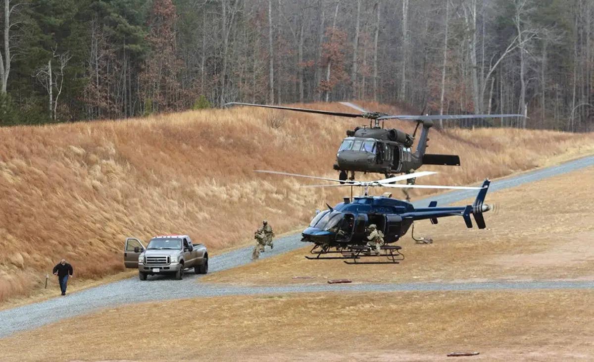 An FBI HRT personnel, with support from one of some of the unit's helicopters – UH-60M Black Hawk, behind, and a Bell Model 407, in front – participate in an exercise to stop a suspect vehicle and detain its occupants.&nbsp;<em>GAO</em><br>