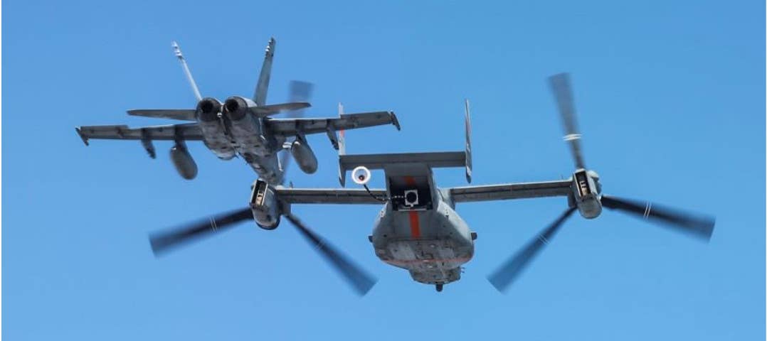 A Marine Corps MV-22B fitted with a probe-and-drogue aerial refueling system works with one of that service's F/A-18C/D Hornets during a test. <em>USMC</em>