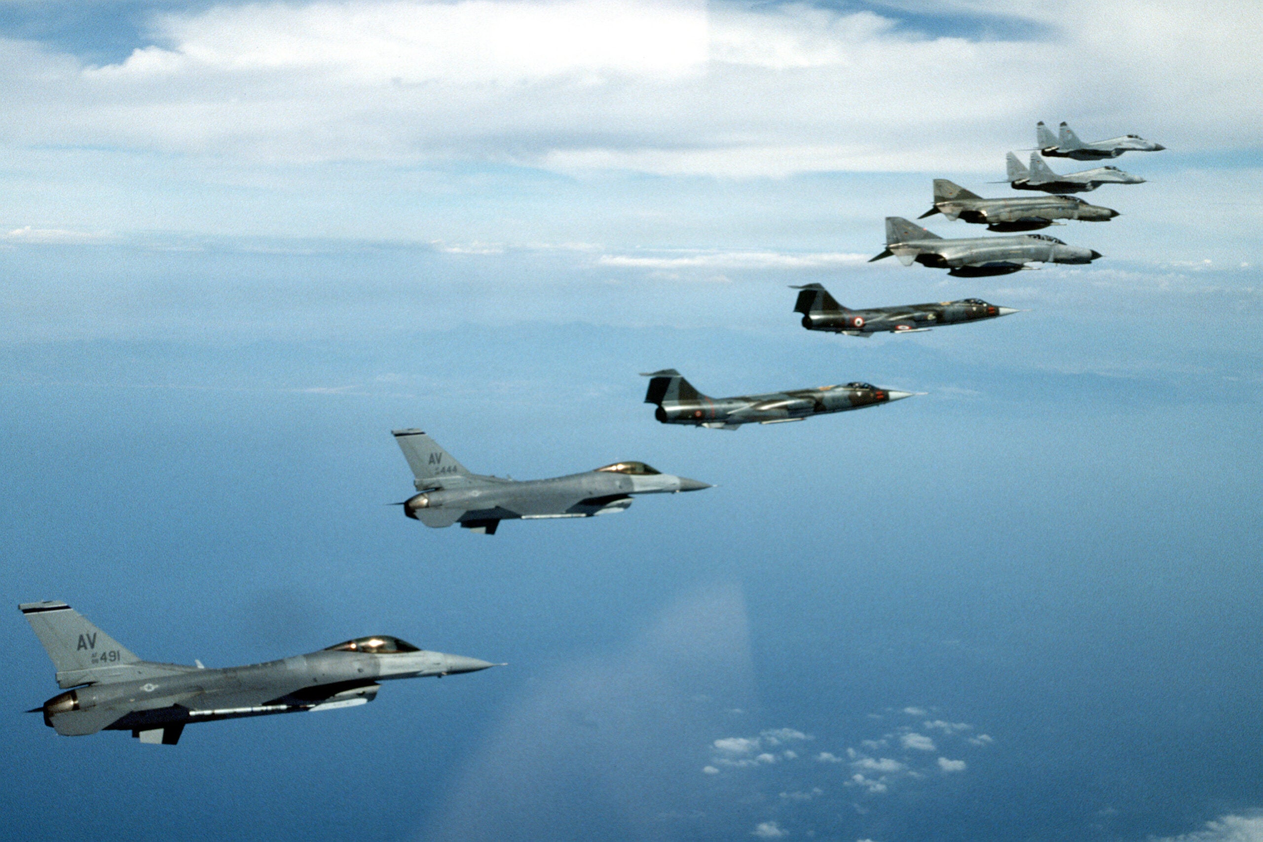 Two U.S. Air Force F-16's, two Italian 104's, two German F-4's and two German MiG-29's fly in.  The three nations' aircraft flew in a joint training effort practicing Dissimilar Air Combat Training.