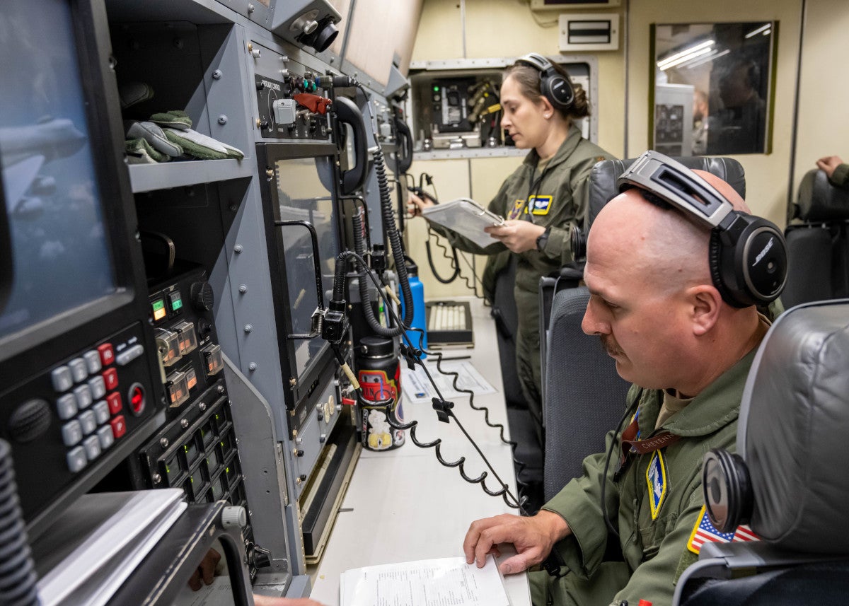 U.S. Air Force Maj. Hayden McVeigh (front), 625th Strategic Operations Squadron deputy missile combat crew commander-airborne, and Maj. Grazia Castagna, 625th Strategic Operations Squadron missile combat crew commander-airborne, review a pre-launch checklist aboard a U.S. Navy E-6B Mercury during an Operational Test Launch of an unarmed Intercontinental Ballistic Missile, April 18, 2023.