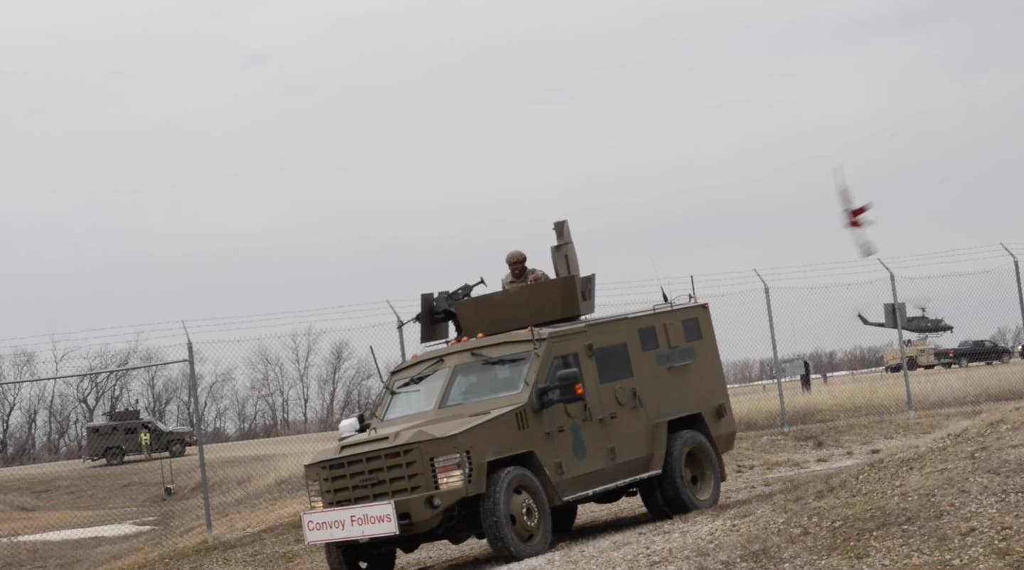 A dummy rifle (upper-right) seen being thrown through the air toward the convoy vehicle. <em>AFGSC</em>