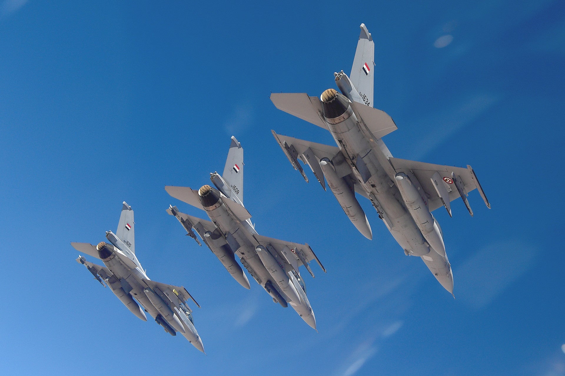Three Iraqi Air Force F-16 Fighting Falcons fly in formation during a training sortie above an undisclosed location, July 18, 2019. U.S. Airmen from the 370th Air Expeditionary Advisory Group partner with Iraqi airmen to conduct advise and assist operations to enable the continuous establishment of security across Iraq. The Coalition operates in close coordination with and by the invitation of the Government of Iraq. (U.S. Air Force photo by Staff Sgt. Chris Drzazgowski)