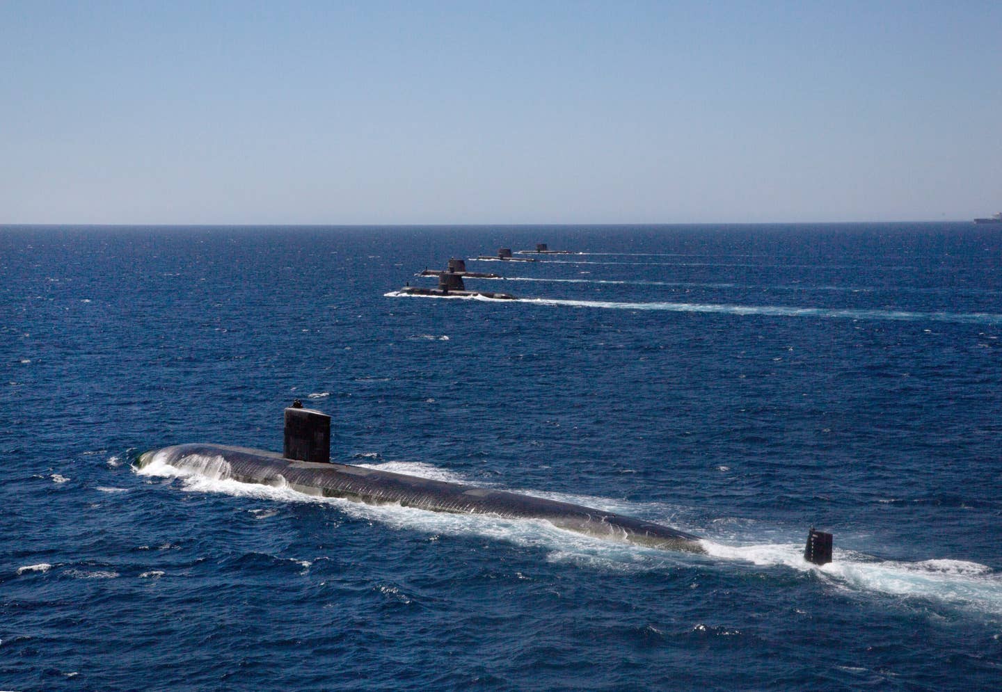 The <em>Los Angeles</em> class submarine USS <em>Santa Fe</em> transits in formation on the surface with Royal Australian Navy <em>Collins</em> class submarines HMAS <em>Collins</em>, HMAS <em>Farncomb</em>, HMAS <em>Dechaineux</em>, and HMAS <em>Sheean</em> in the West Australian Exercise Area in February 2019. <em>Australian Department of Defense</em>