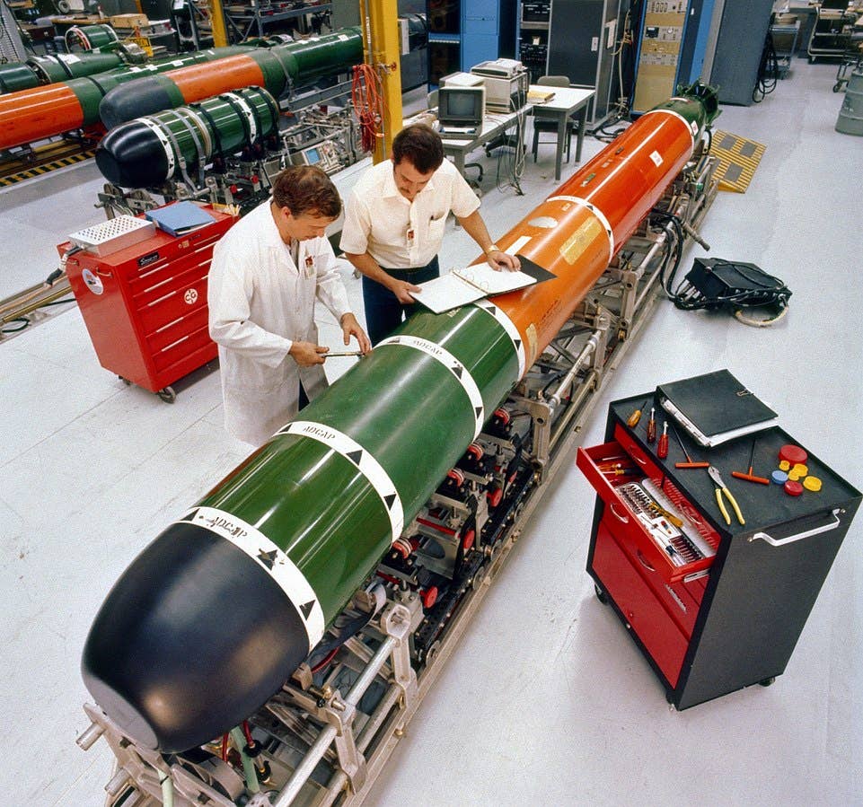 Technicians perform maintenance on a Mark 48 Advanced Capabilities torpedo at Keyport, Washington in 1982. <em>U.S. Navy</em>