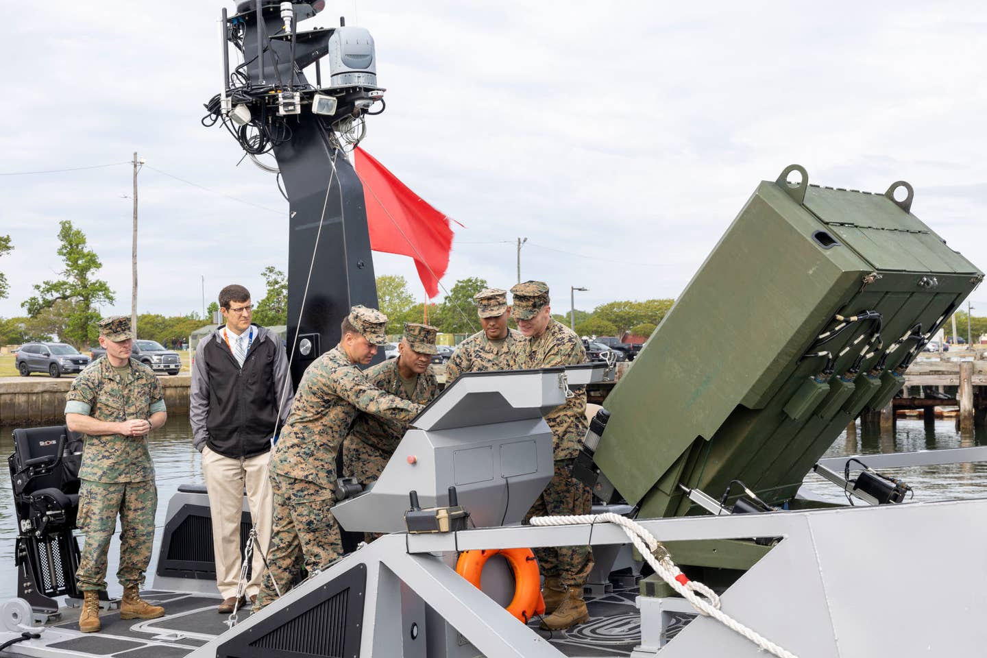 A closer look at the Hero-120 launcher and other parts of the LRUSV that was at the center of Lt. Gen. Brian Cavanaugh's visit last month to Joint Expeditionary Base Little Creek-Fort Story. Cavanaugh is seen here at center, with another Marine pointing out something to him on the drone boat's main onboard control system. <em>USMC</em>