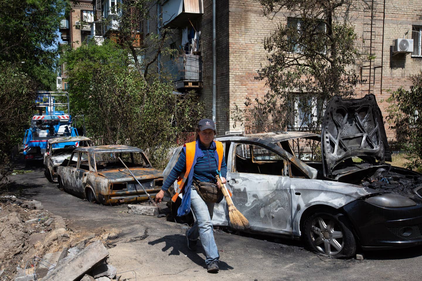 KYIV, UKRAINE - MAY 30: Utility worker walks near cars destroyed by a Russian drone explosion in central Kyiv, Ukraine on May 30, 2023. <em>Photo by Oleksii Chumachenko/Anadolu Agency via Getty Images</em>