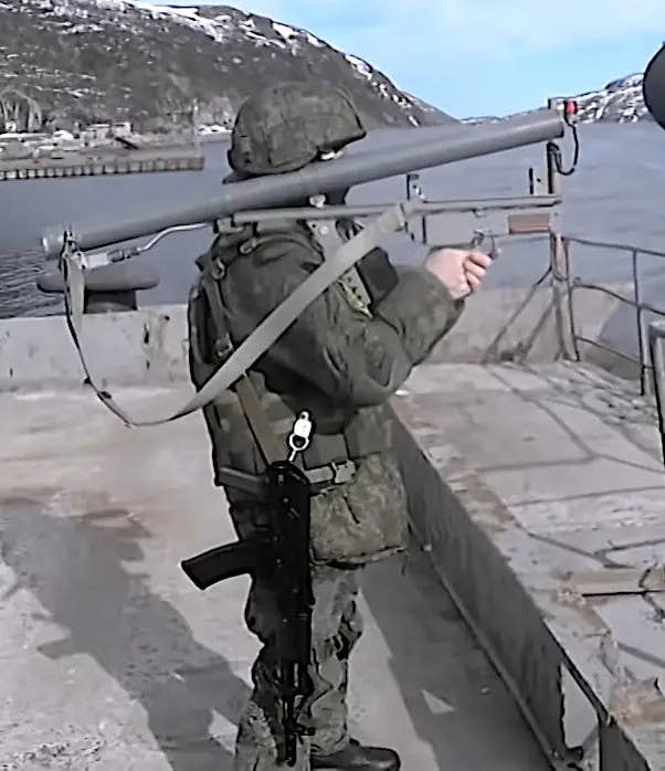 A member of Russia's armed forces aims a man-portable DP-61 anti-diver weapon. <em>TV Zvezda capture</em>