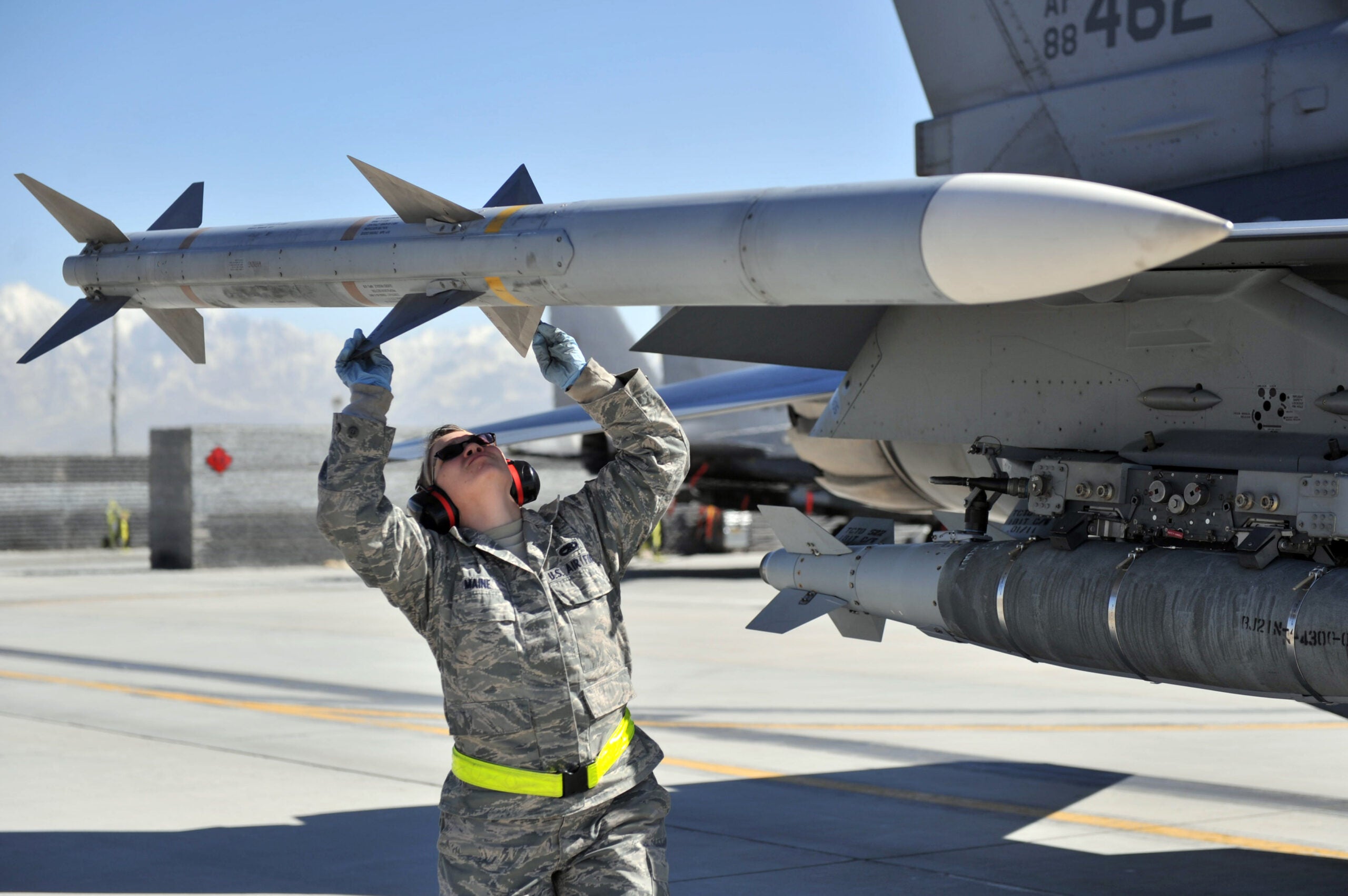 Senior Airman Hilarie Maine, 455th Expeditionary Aircraft Maintenance Squadron, ensures a missile is secured on the wing tip of on an F-16 Fighting Falcon before taking off during an end of runway check at Bagram Airfield, Afghanistan, March 9, 2011. The EOR check is a final inspection to verify there is nothing wrong with the jet before it departs. Airman Maine is deployed from Hill Air Force Base, Utah. (U.S. Air Force photo by Senior Airman Sheila deVera)