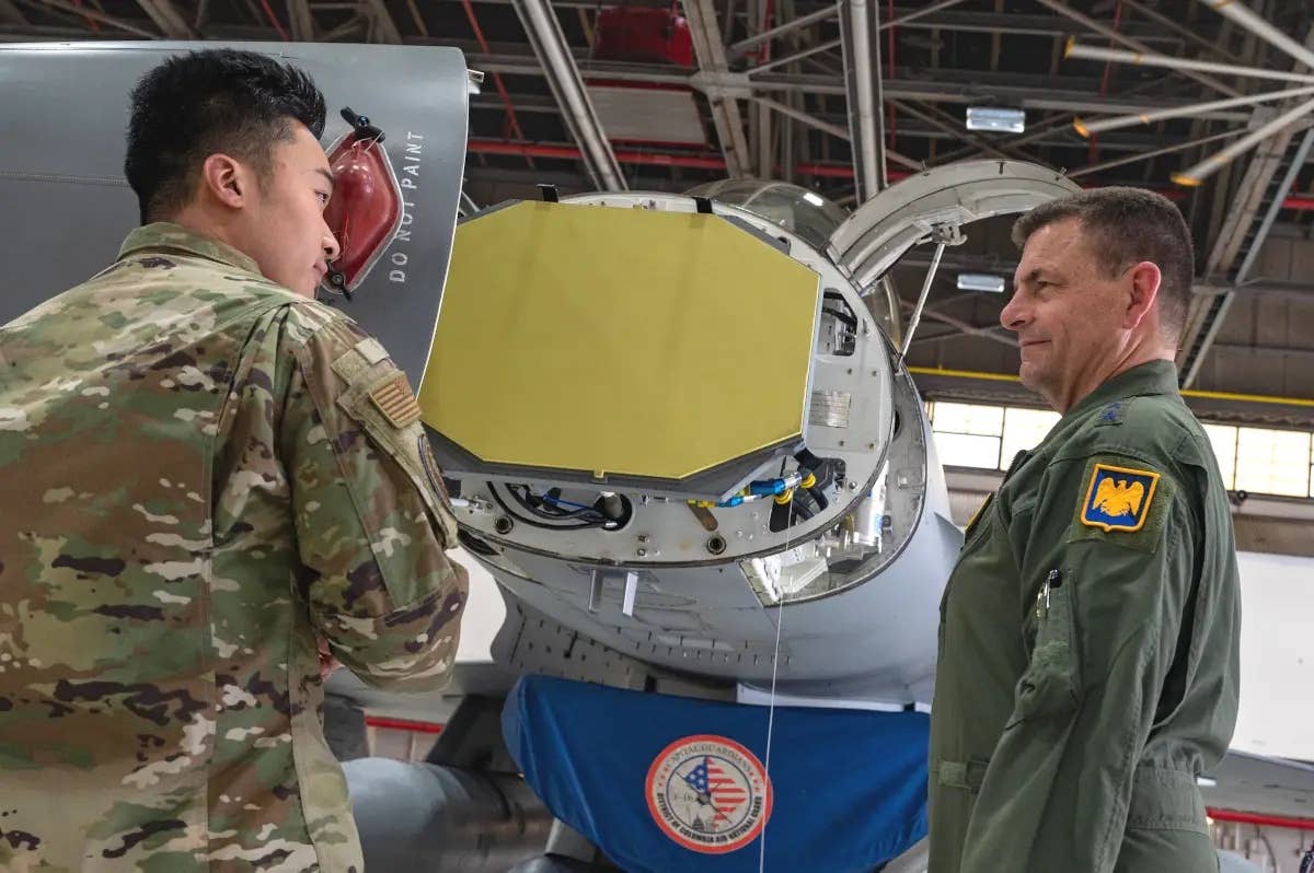Air Force Lt. Gen. Michael Loh, the Director of the Air National Guard, at right, listens to details about the AN/APG-83 radar, as seen here install in an F-16. This picture was taken at a ceremony to mark the completion of an upgrade program to add these radars to 72 Air National Guard jets. <em>Northrop Grumman</em>