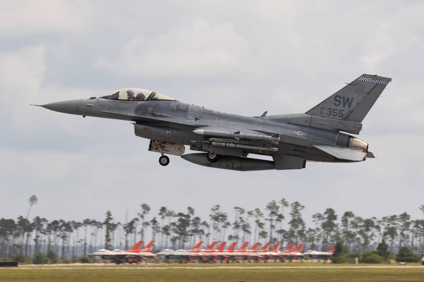 An F-16C gets airborne. In the background is the QF-16 "death row" with jets that are earmarked for shooting down. <em>Richard Collens</em>