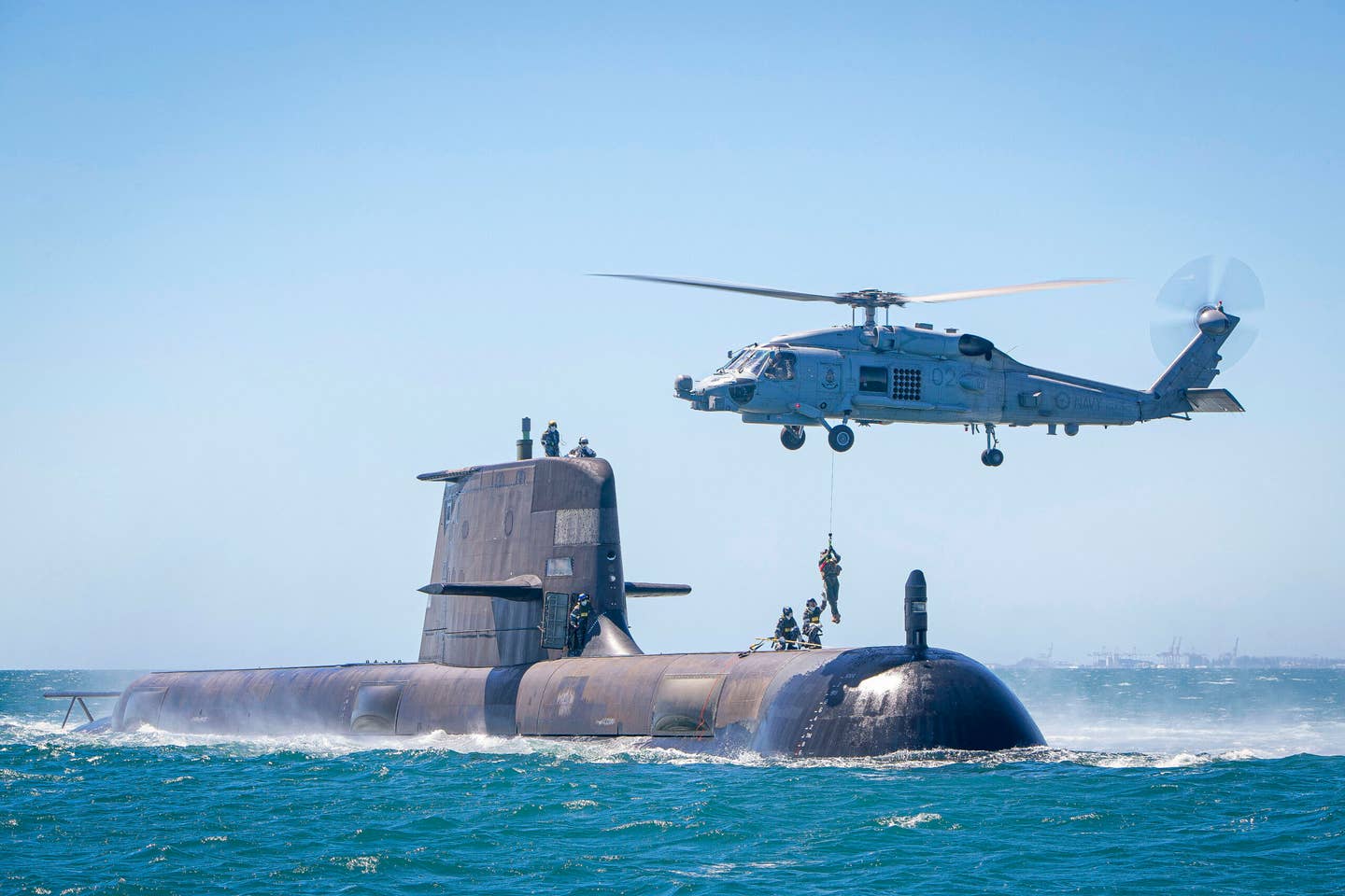 The <em>Collins</em> class submarine HMAS <em>Rankin</em> conducts helicopter transfers in Cockburn Sound, Western Australia, as part of training assessments to ensure the boat is ready to deploy. <em>Australian Department of Defense</em>