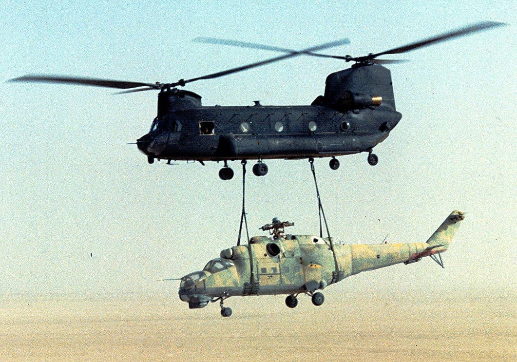 A U.S. Army MH-47D from the 160th Special Operations Aviation Regiment with the stripped-down Mi-25 Hind attack helicopter slung underneath during Operation Mount Hope III. <em>U.S. Army</em>