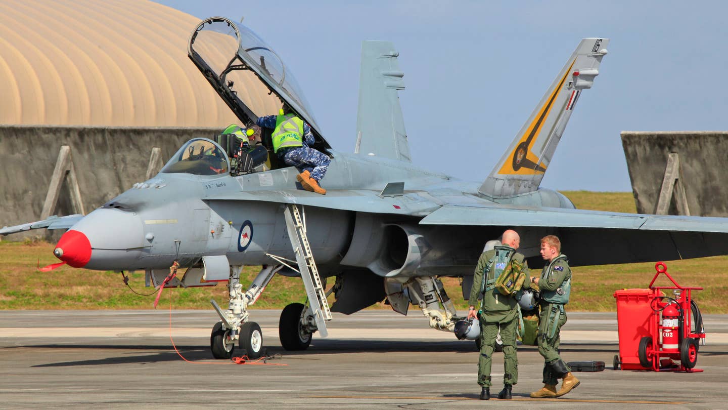 RAAF F/A-18 Hornet pilots discuss their mission after landing at Andersen Air Force Base, Guam. (Royal Australian Air Force photo by Cpl. David Gibbs)