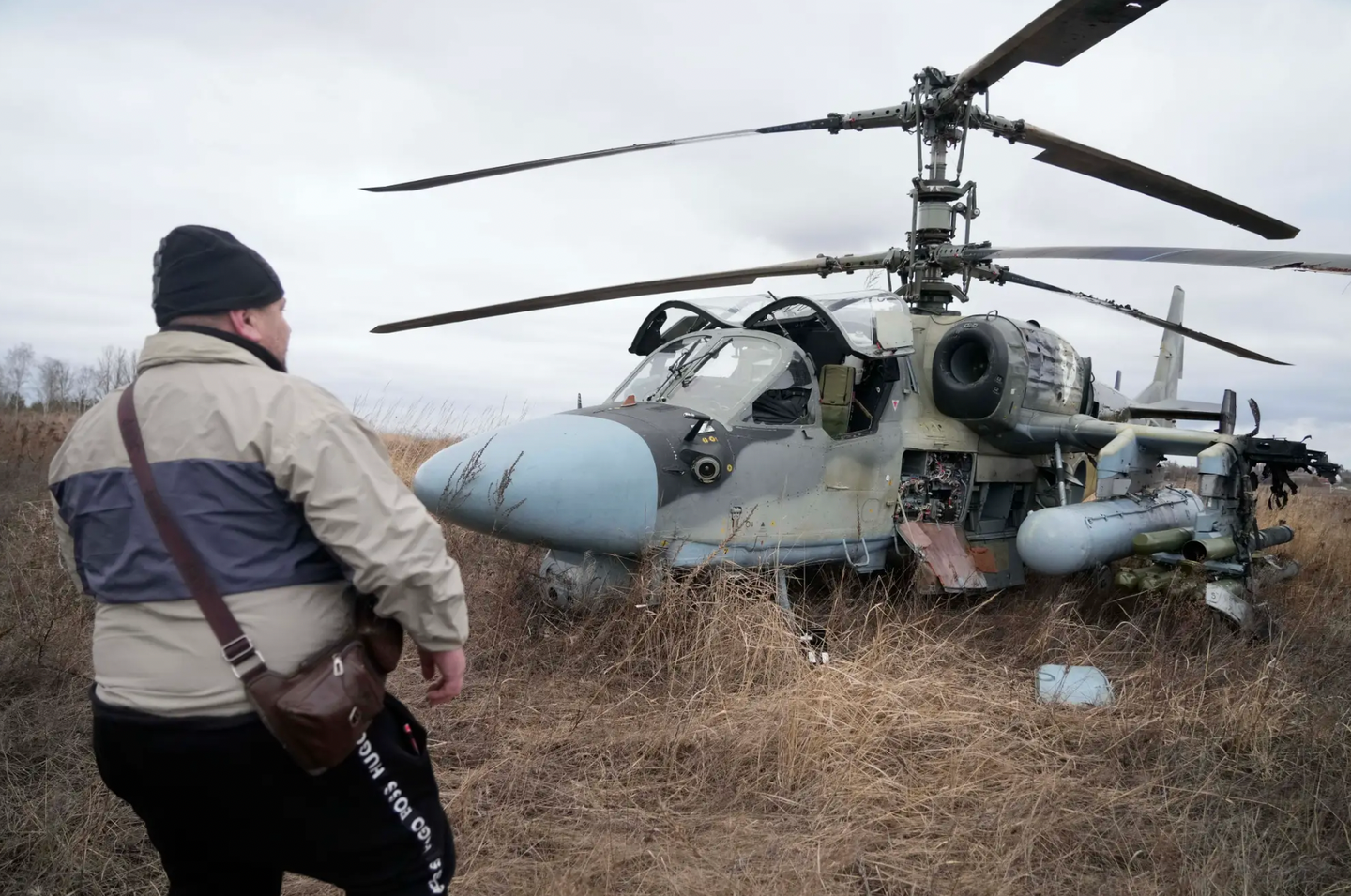 A man stands in front of a Russian Ka-52 forced to land in a field outside Kyiv, Ukraine, on February 24, 2022, on the first day of the full-scale invasion.&nbsp;<em>AP Photo/Efrem Lukatsky</em>