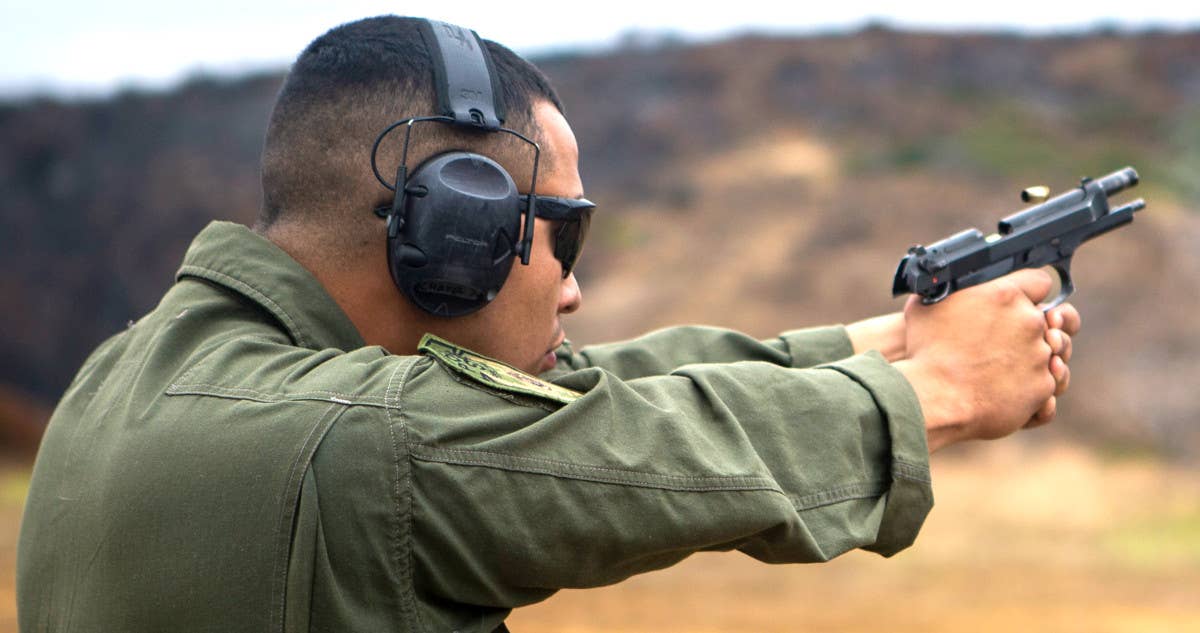 A Marine fires an M9A1 pistol. <em>USMC</em>