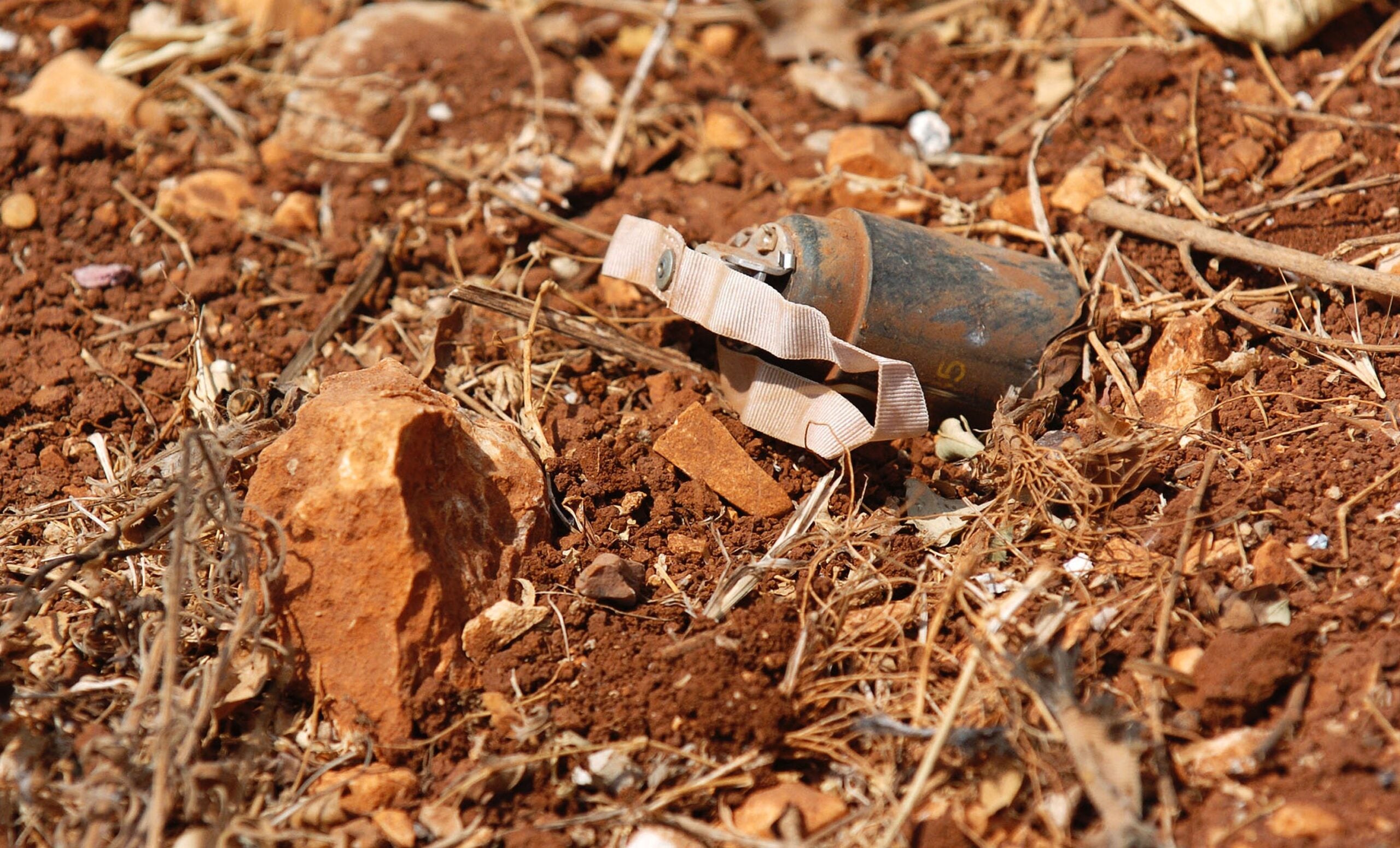 YOHMOR, LEBANON - AUGUST 21:  An unexploded cluster bomb identified by members of the Mine Advisory Group (MAG) rests in a backyard garden August 21, 2006 in Yohmor, Lebanon. MAG is clearing areas of dangerous unexploded submunitions in southern Lebanon that came under Isreali attack during incursions to dislodge Hezbollah fighters. According to the U.N., some 145  bomblets litter 10 identified areas where refugees are beginning to return to their homes.  (Photo by Scott Peterson/Getty Images)