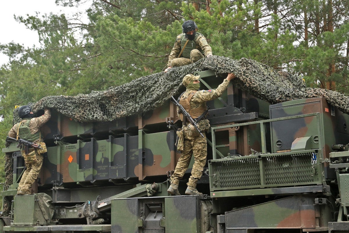 Ukrainian personnel remove camouflage netting from a Patriot launcher, which is loaded with missile canisters associated with older interceptors like the PAC-2-series. Ukrainian Air Force Ukrainian Air Force