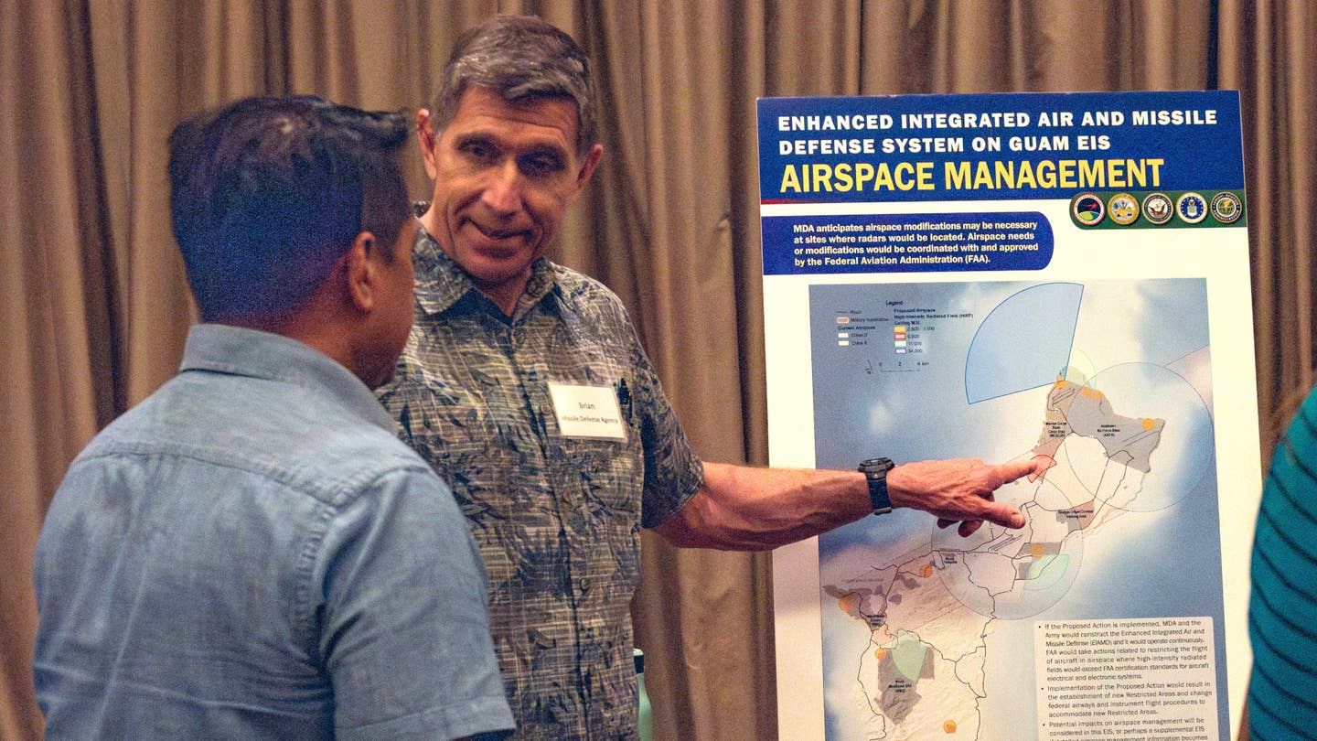 A Missile Defense Agency representative points to a poster discussing potential impacts from the planned Enhanced Integrated Air and Missile Defense system during a "public scoping meeting" with residents of Guam on August 2, 2023. <em>USN</em>