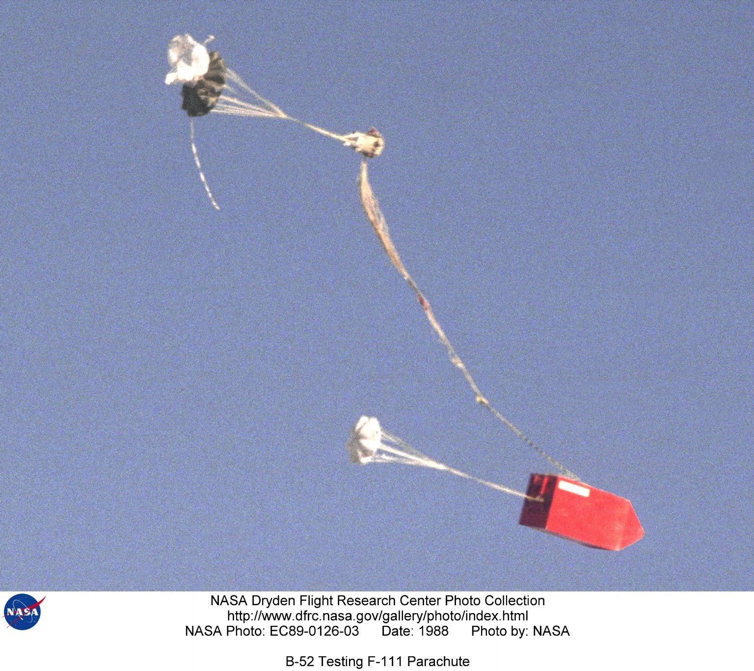 The main parachute begins to deploy on the mock-up of an F-111 "Aardvark" bomber cockpit section after being dropped from NASA's B-52 mothership during 1988 flight tests on improved parachute systems for the Air Force bomber. The F-111's ejection system separated the entire cockpit from the rest of the aircraft, and a large parachute was then deployed to lower the cockpit section to the ground. NASA B-52, Tail Number 008, is an air launch carrier aircraft, "mothership," as well as a research aircraft platform that has been used on a variety of research projects. The aircraft, a "B" model built in 1952 and first flown on June 11, 1955, is the oldest B-52 in flying status and has been used on some of the most significant research projects in aerospace history. Some of the significant projects supported by B-52 008 include the X-15, the lifting bodies, HiMAT (highly maneuverable aircraft technology), Pegasus, validation of parachute systems developed for the space shuttle program (solid-rocket-booster recovery system and the orbiter drag chute system), and the X-38. The B-52 served as the launch vehicle on 106 X-15 flights and flew a total of 159 captive-carry and launch missions in support of that program from June 1959 to October 1968. Information gained from the highly successful X-15 program contributed to the Mercury, Gemini, and Apollo human spaceflight programs as well as space shuttle development. Between 1966 and 1975, the B-52 served as the launch aircraft for 127 of the 144 wingless lifting body flights. In the 1970s and 1980s, the B-52 was the launch aircraft for several aircraft at what is now the Dryden Flight Research Center, Edwards, California, to study spin-stall, high-angle-of attack, and maneuvering characteristics. These included the 3/8-scale F-15/spin research vehicle (SRV), the HiMAT (Highly Maneuverable Aircraft Technology) research vehicle, and the DAST (drones for aerodynamic and structural testing). The aircraft supported the development of parachute recovery systems used to recover the space shuttle solid rocket booster casings. It also supported eight orbiter (space shuttle) drag chute tests in 1990. In addition, the B-52 served as the air launch platform for the first six Pegasus space boosters. During its many years of service, the B-52 has undergone several modifications. The first major modification was made by North American Aviation (now part of Boeing) in support of the X-15 program. This involved creating a launch-panel-operator station for monitoring the status of the test vehicle being carried, cutting a large notch in the right inboard wing flap to accommodate the vertical tail of the X-15 aircraft, and installing a wing pylon that enables the B-52 to carry research vehicles and test articles to be air-launched/dropped. Located on the right wing, between the inboard engine pylon and the fuselage, this wing pylon was subjected to extensive testing prior to its use. For each test vehicle the B-52 carried, minor changes were made to the launch-panel operator's station. Built originally by the Boeing Company, the NASA B-52 is powered by eight Pratt &amp; Whitney J57-19 turbojet engines, each of which produce 12,000 pounds of thrust. The aircraft's normal launch speed has been Mach 0.8 (about 530 miles per hour) and its normal drop altitude has been 40,000 to 45,000 feet. It is 156 feet long and has a wing span of 185 feet. The heaviest load it has carried was the No. 2 X-15 aircraft at 53,100 pounds. Project manager for the aircraft is Roy Bryant.

NASA Identifier: NIX-EC89-0126-03
