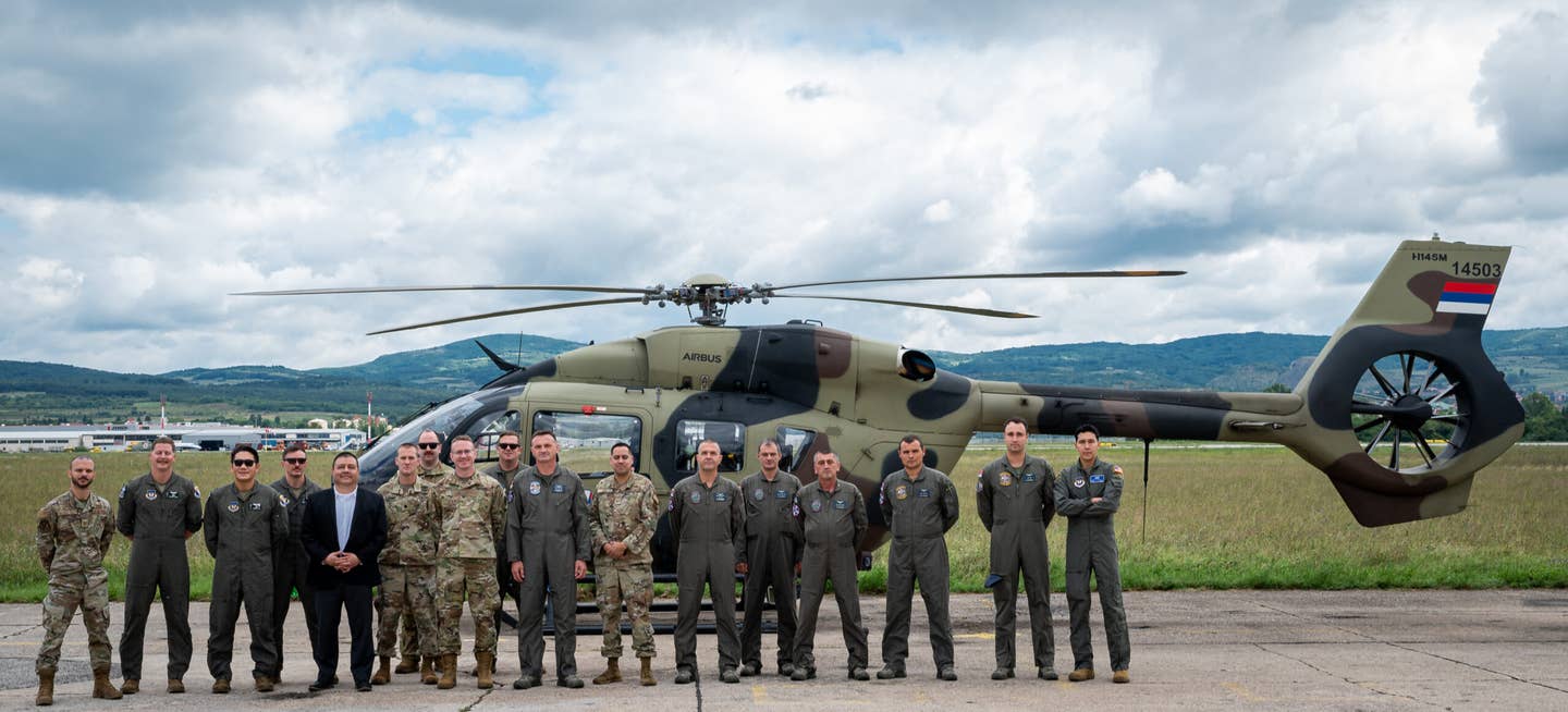 U.S. Air Force airmen assigned to the 435th Contingency Response Squadron, 31st Fighter Wing, and Serbian Air Force 119th Mixed Helicopter Squadron stand in front of a H145M helicopter, at Sgt./Pilot Mihajlo Petrovic Air Base, Serbia, Aug. 8, 2023. <em>U.S. Air Force photo by Airman 1st Class Edgar Grimaldo</em><br>