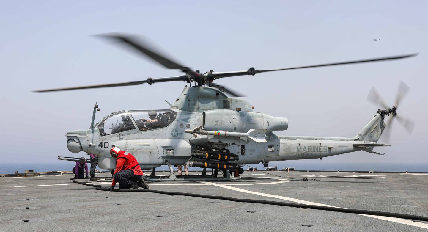 A US Marine Corps AH-1Z Viper attack helicopter armed with AIM-9M Sidewinder, AGM-114P Hellfire, and AGM-179A JAGM missiles on the deck of the USS Carter Hall in the Gulf of Oman on August 14, 2023. <em>USN</em>