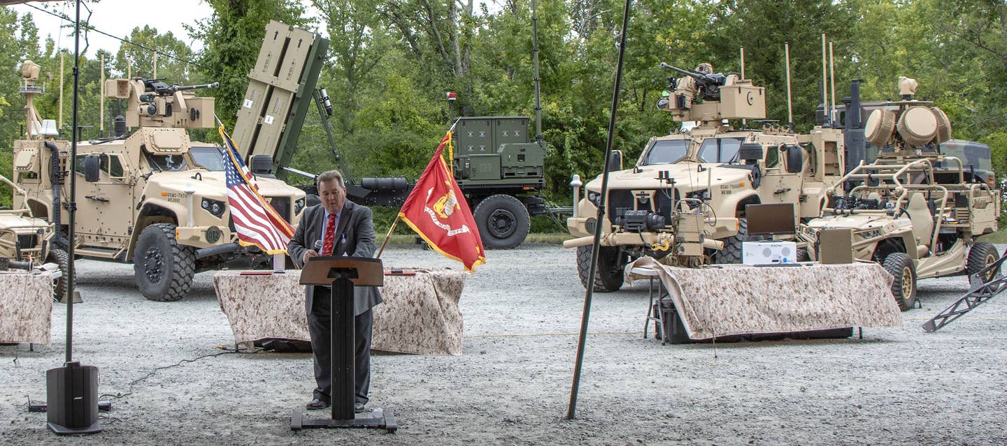 Two variants of the JTLV-based Marine Air Defense Integrated System (MADIS), as well as MRZR-based Light Marine Air Defense Integrated System (LMADIS) on display at an event at Marine Corps Base Quantico, Virginia, in July 2023. An MRIC Expeditionary Launcher can also be seen in the background. <em>USMC</em>