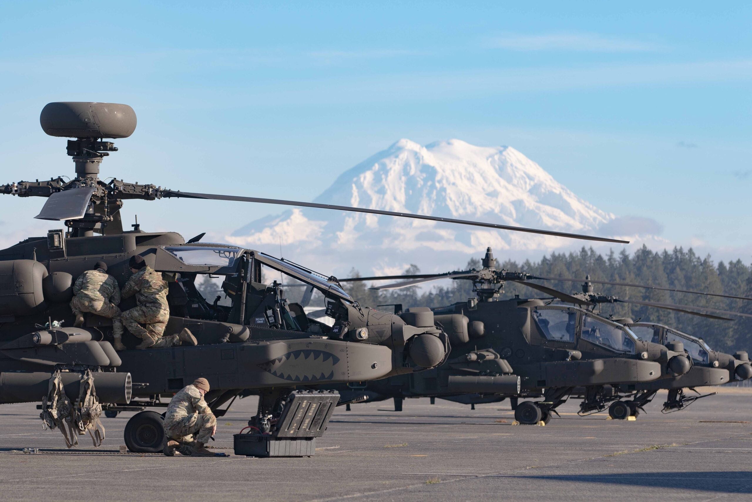 Soldiers assigned to 16th Combat Aviation Brigade perform maintenance on an AH-64E Apache attack helicopter at Joint Base Lewis-McChord, Wash. on Nov. 8, 2022. Mount Rainier is visible in the background. (U.S. Army photo by Capt. Kyle Abraham, 16th Combat Aviation Brigade)