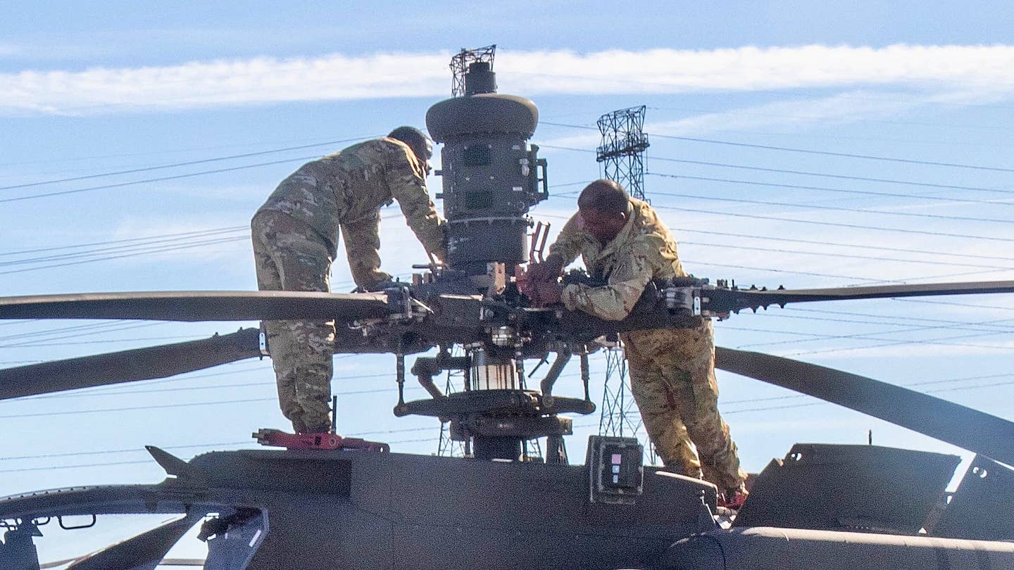 Soldiers assigned to the 3rd Combat Aviation Brigade, 3rd Infantry Division, fold the blades of an AH-64 Apache as part of port operations in Jacksonville, Florida, Feb.14, 2023. 3rd CAB is preparing to support Atlantic Resolve, a nine-month rotation that provides rotational deployments of combat-credible forces to Europe to show our commitment to NATO while building readiness, increasing interoperability and enhancing the bonds between ally partner militaries (U.S. Army photo by Sgt Caitlin Wilkins, 3rd Combat Aviation Brigade)