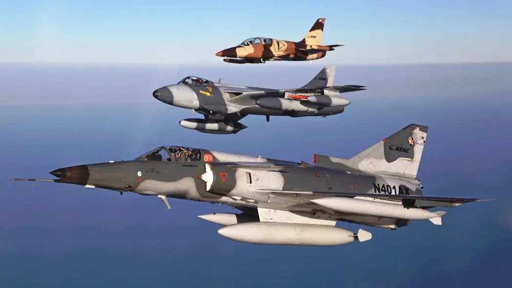 A good example of contractor-owned and operated aggressor jets in use today. These aircraft, which all belong to the Airborne Tactical Advantage Company (ATAC) are, from front to back, an F-21 Kfir, a Hawker Hunter Mk 58, and a L-39 Albatros. <em>ATAC</em>