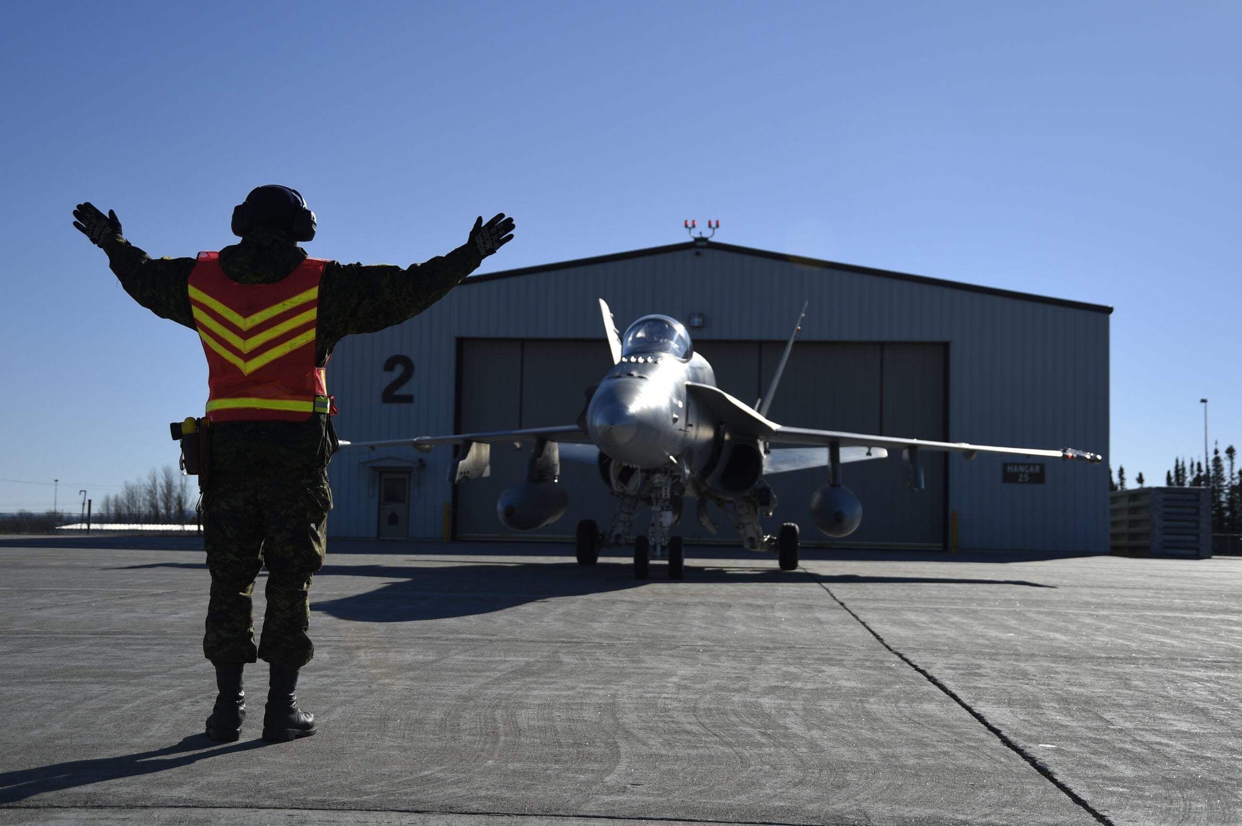 Royal Canadian Air Force Cpl. Charles Milot, 425 Tactical Fighter Squadron engine technician, marshals a CF-18 Hornet during Vigilant Shield 15 at 5 Wing Goose Bay, Newfoundland and Labrador, Canada, Oct. 23, 2014. Vigilant Shield field training exercise is a bi-national NORAD Command exercise which provides realistic training and practice for American and Canadian forces in support of respective national strategy for North America’s defense. NORAD ensures U.S. and Canadian air sovereignty through a network of alert fighters, tankers, airborne early warning aircraft, and ground-based air defense assets cued by interagency and defense surveillance radars. (U.S. Air Force photo/Senior Airman Justin Wright)