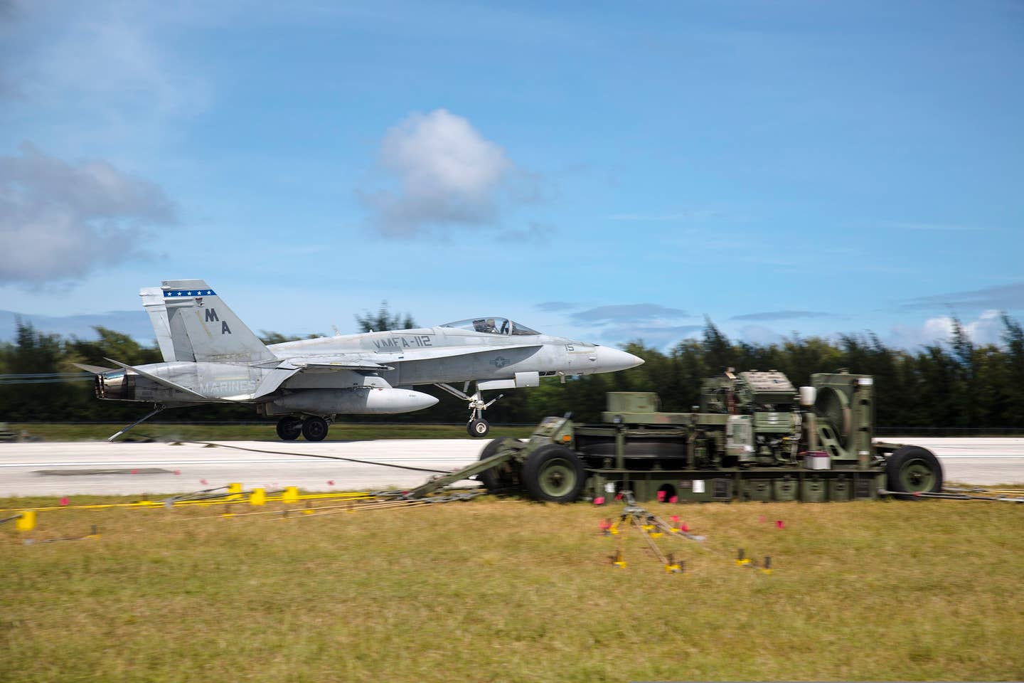 A USMC Hornet executes short-field recovery operations using a mobile arresting gear system on the island of Tinian. (U.S. Marine Photo by Lance Cpl. Antonio Rubio/Released)