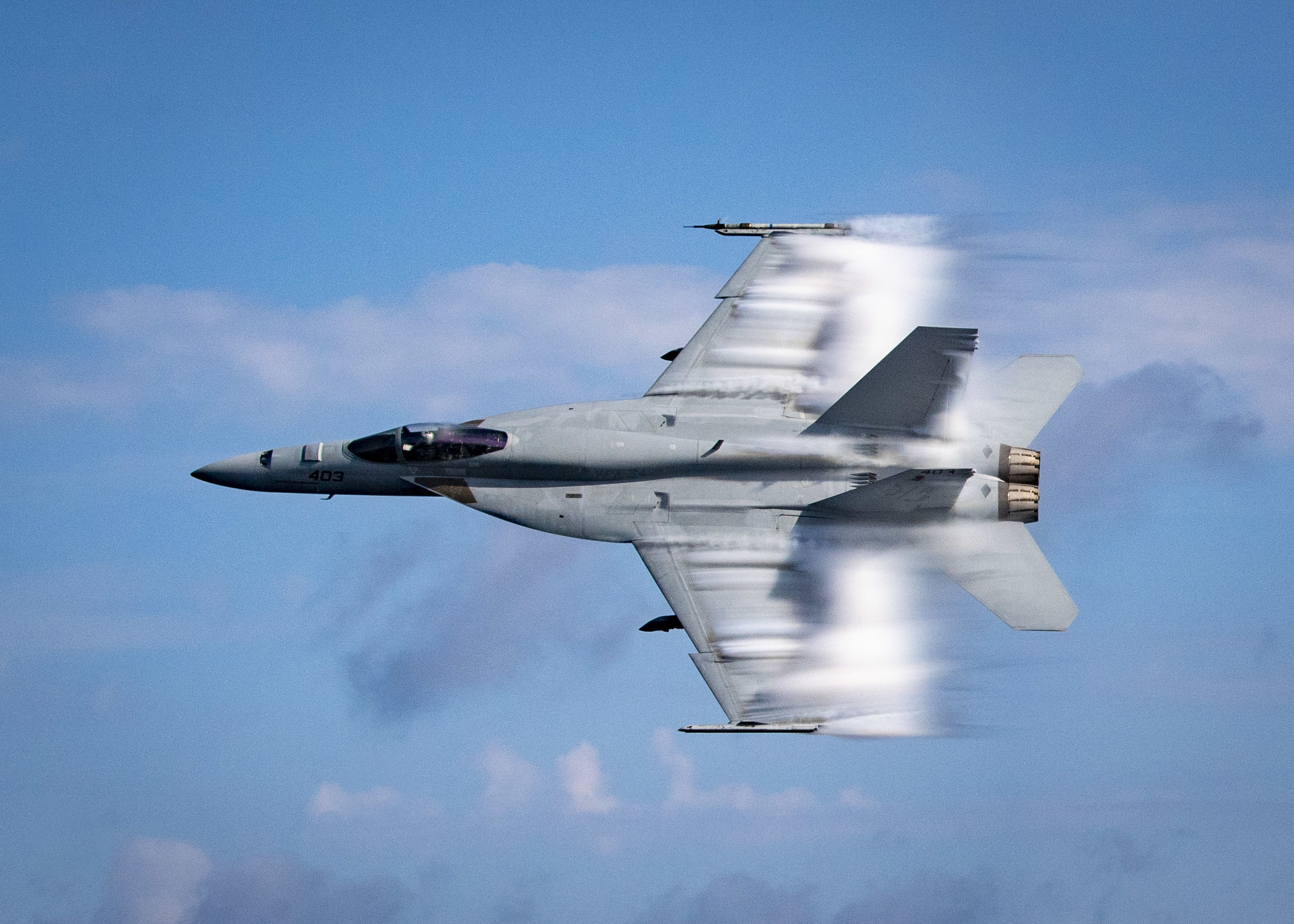 U.S. Navy Lt. Cmdr. Benjamin Orloff, assigned to the "Blue Blasters" of Strike Fighter Squadron 34, conducts a supersonic pass in an F/A-18E Super Hornet next to the guided-missile destroyer USS Gridley (DDG 101) during a training exercise in the Atlantic Ocean, Aug. 23, 2019. Gridley is underway on a regularly-scheduled deployment as the flagship of Standing NATO Maritime Group 1 to conduct maritime operations and provide a continuous maritime capability for NATO in the northern Atlantic. (U.S. Navy photo by Mass Communication Specialist 2nd Class Cameron Stoner)