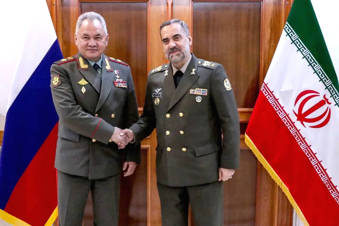 Russian Defense Minister Sergei Shoigu shakes hands with his Iranian counterpart, Mohammad Reza Ashtiani, during his visit to Tehran. <em>Russian Ministry of Defense</em>
