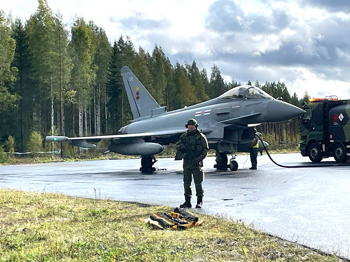 A member of the Finnish Defense Forces guards an RAF Typhoon as it is refueled during Baana 23. <em>Crown Copyright</em>