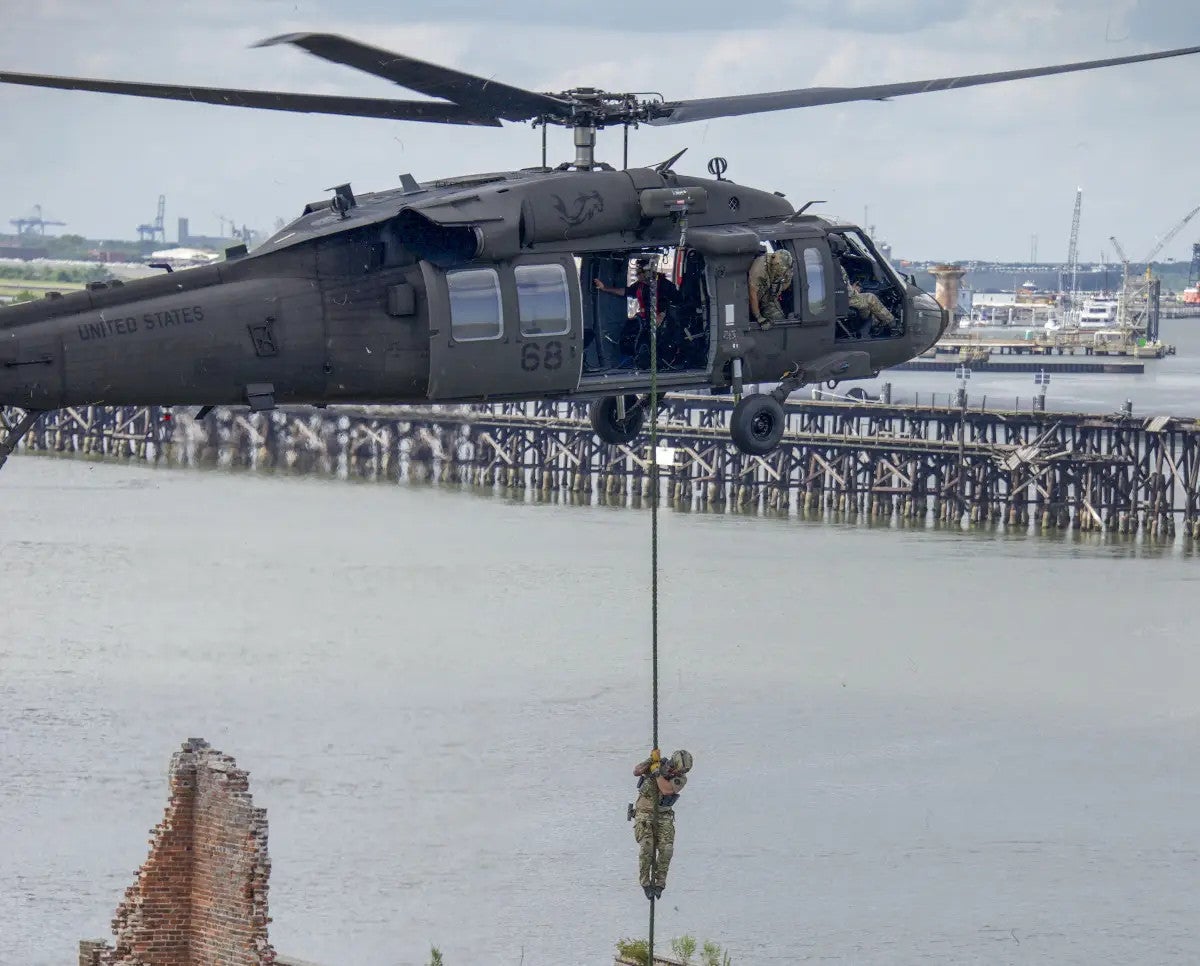 A HRT member rappels from a UH-60M during the August exercise in South Carolina. The two "Eggbeater" or "O Wing" UHF SATCOM antennas are clearly visible on top. This particular helicopter also has a notable hammerhead shark artwork on the engine cover., FBI 