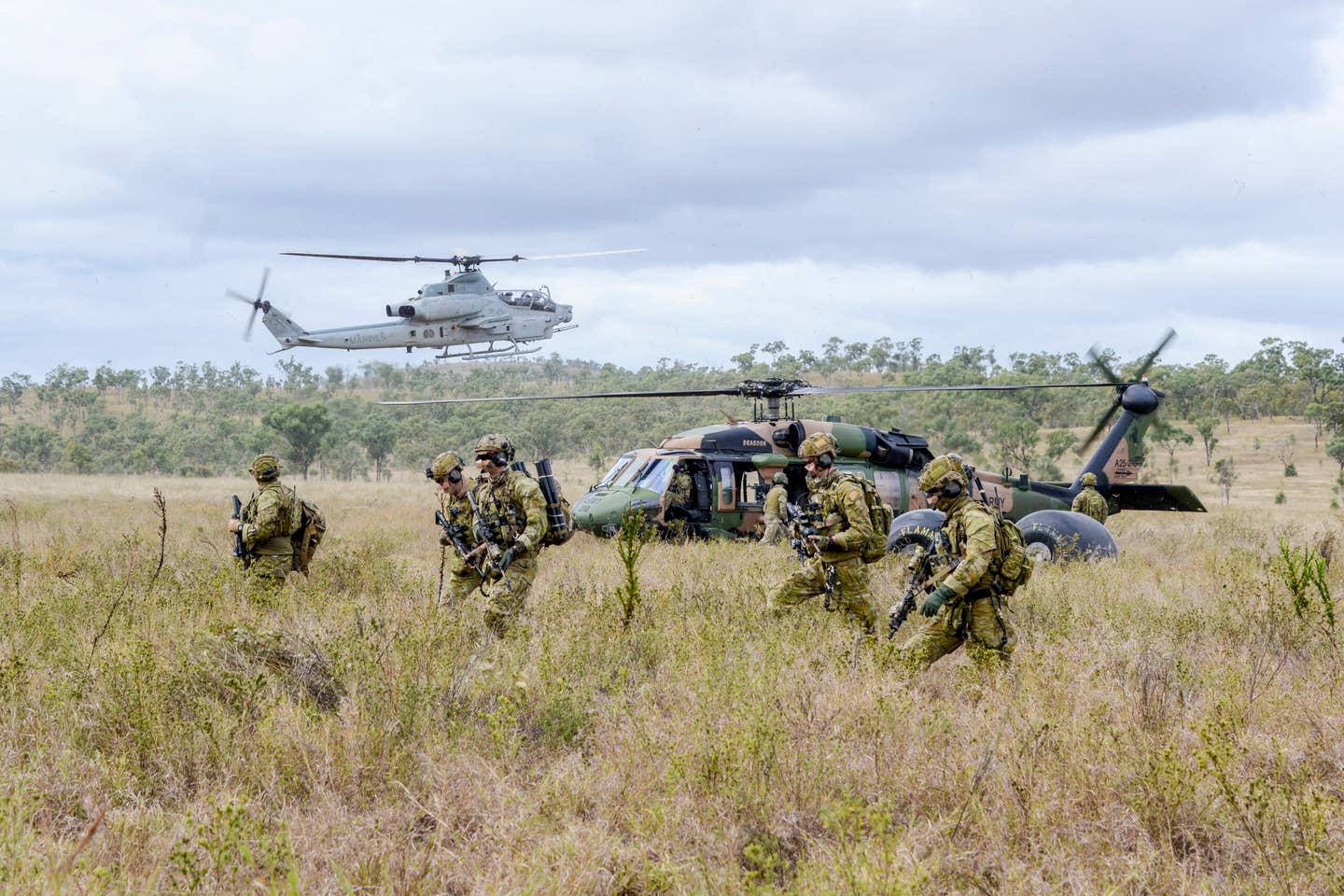 Australian Army soldiers from the 2nd Commando Regiment disembark a 6th Aviation Regiment S-70A-9 Black Hawk at the High Range training area near Townsville, Queensland, during joint training with U.S. Marine Corps AH-1Z Viper gunships as part of Exercise Talisman Sabre 2019. <em>COMMONWEALTH OF AUSTRALIA, DEPARTMENT OF DEFENSE</em>