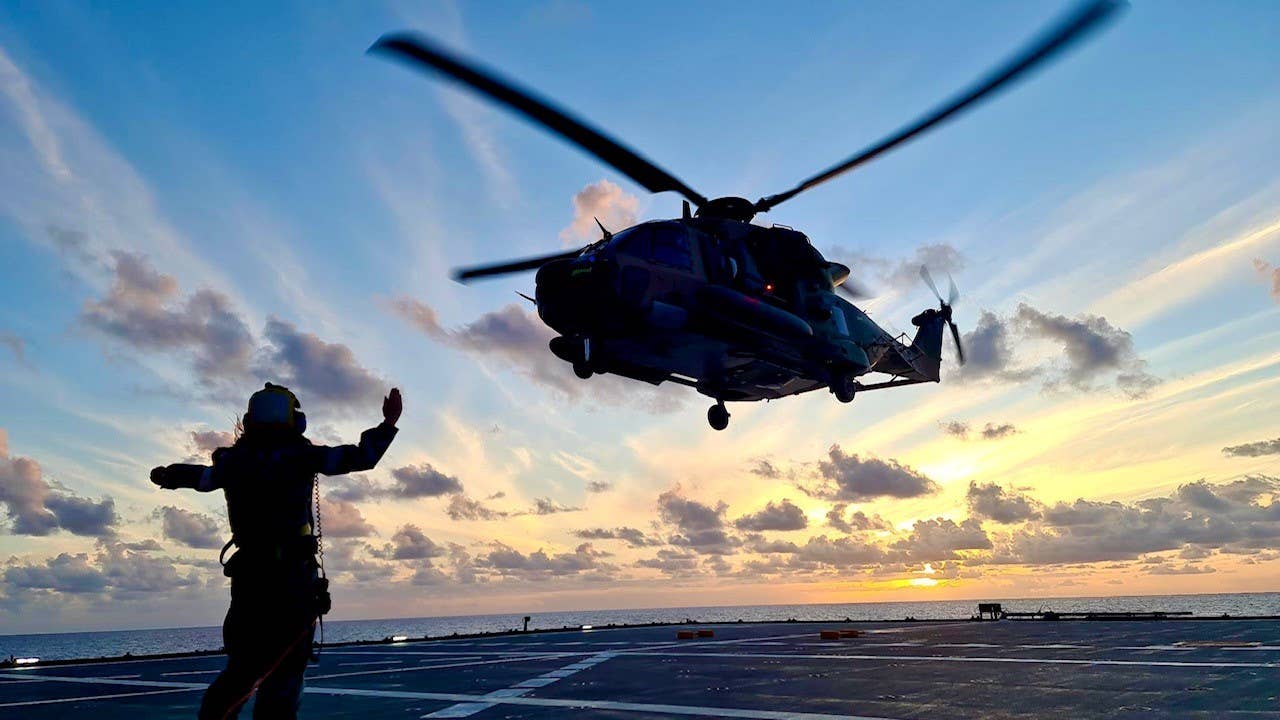 An MRH90 helicopter from 808 Squadron is marshaled in to land on HMAS <em>Supply</em> during first-of-class flight trials off the coast of Queensland. <em>COMMONWEALTH OF AUSTRALIA, DEPARTMENT OF DEFENSE</em>