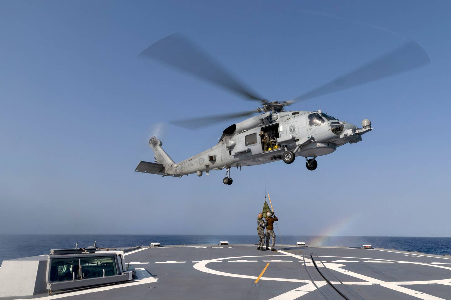 Royal Australian Navy sailors conduct a high-line transfer exercise with an embarked MH-60R from the <em>Anzac</em> class frigate HMAS <em>Toowoomba</em>, off the coast of Western Australia. <em>COMMONWEALTH OF AUSTRALIA, DEPARTMENT OF DEFENSE</em>