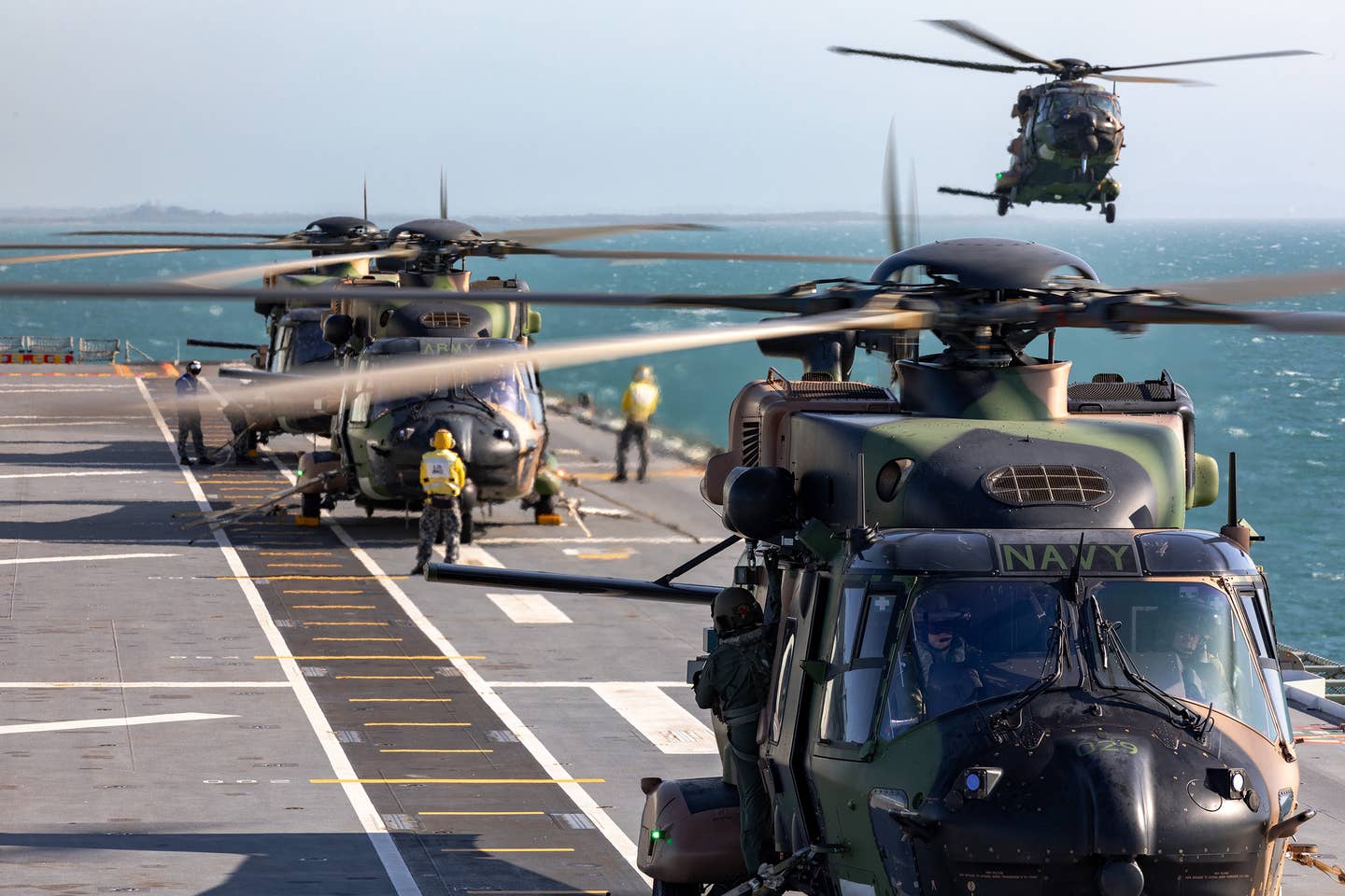 A flight of four Royal Australian Navy and Australian Army MRH90 Taipan helicopters operate off the flight deck of the <em>Canberra</em> class amphibious assault ship HMAS Adelaide. <em>COMMONWEALTH OF AUSTRALIA, DEPARTMENT OF DEFENSE</em><br>