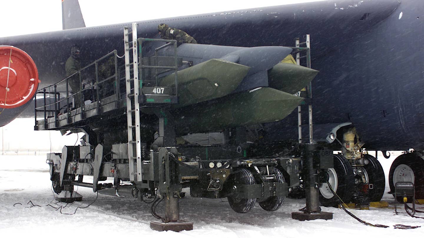 Airmen work to load AGM-129 Advanced Cruise Missiles under the wing of a B-52 bomber. <em>USAF</em>